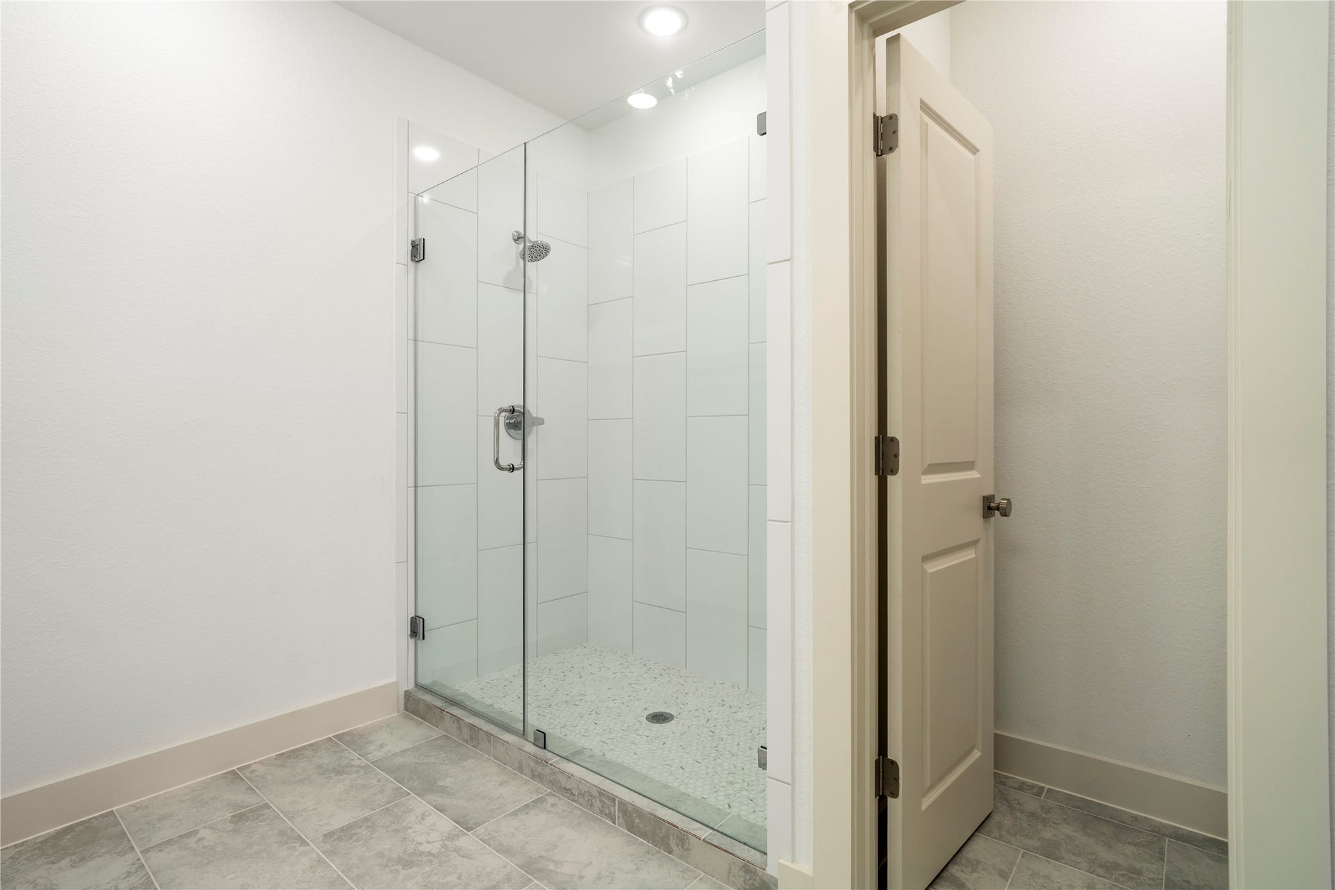 5629 Malmedy Road, Houston, TX 77033 Modern bathroom featuring a sleek glass-enclosed shower with elegant tile flooring.