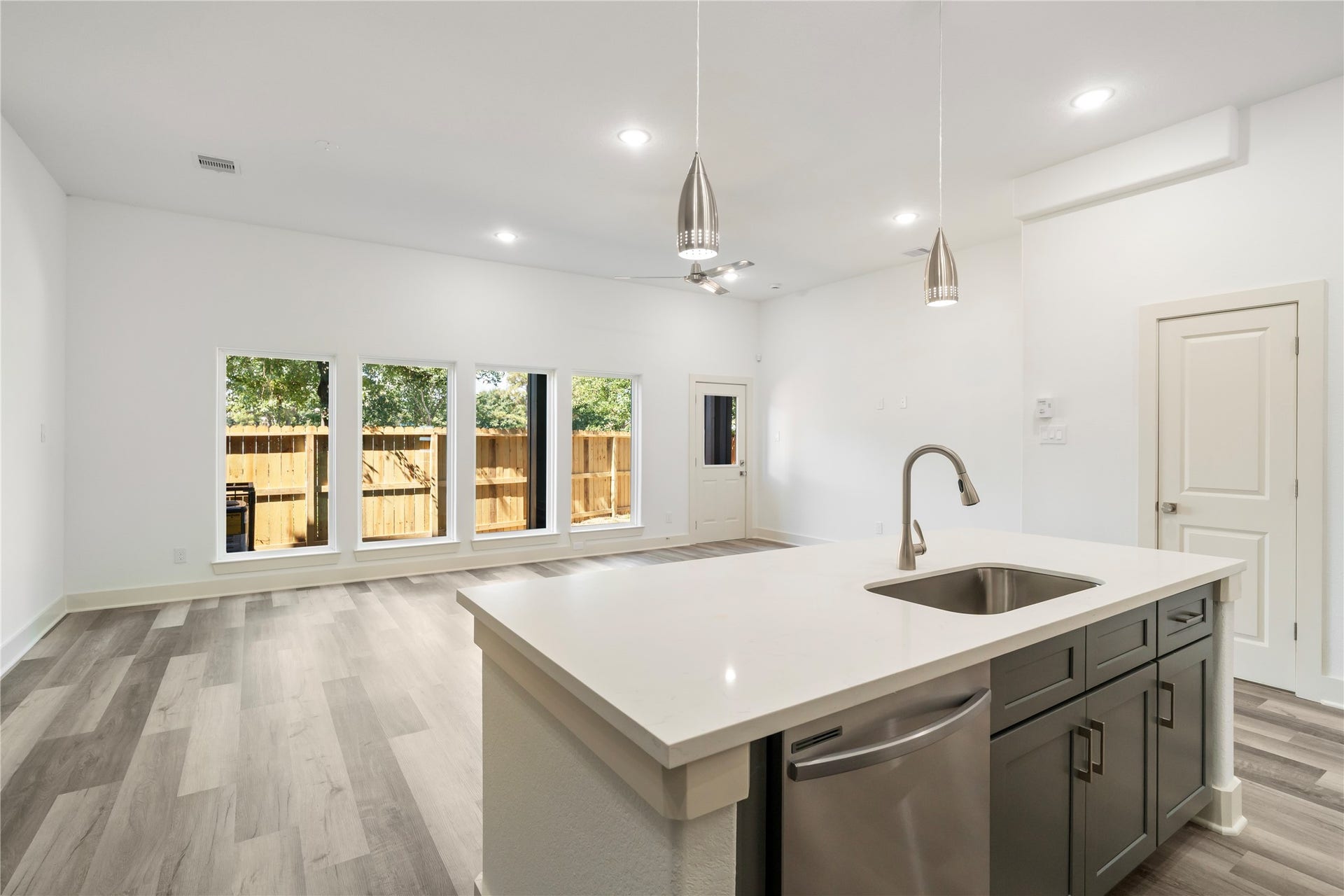 5629 Malmedy Road, Houston, TX 77033 Bright and spacious open-concept living area featuring modern flooring, a sleek kitchen island, and large windows offering plenty of natural light.