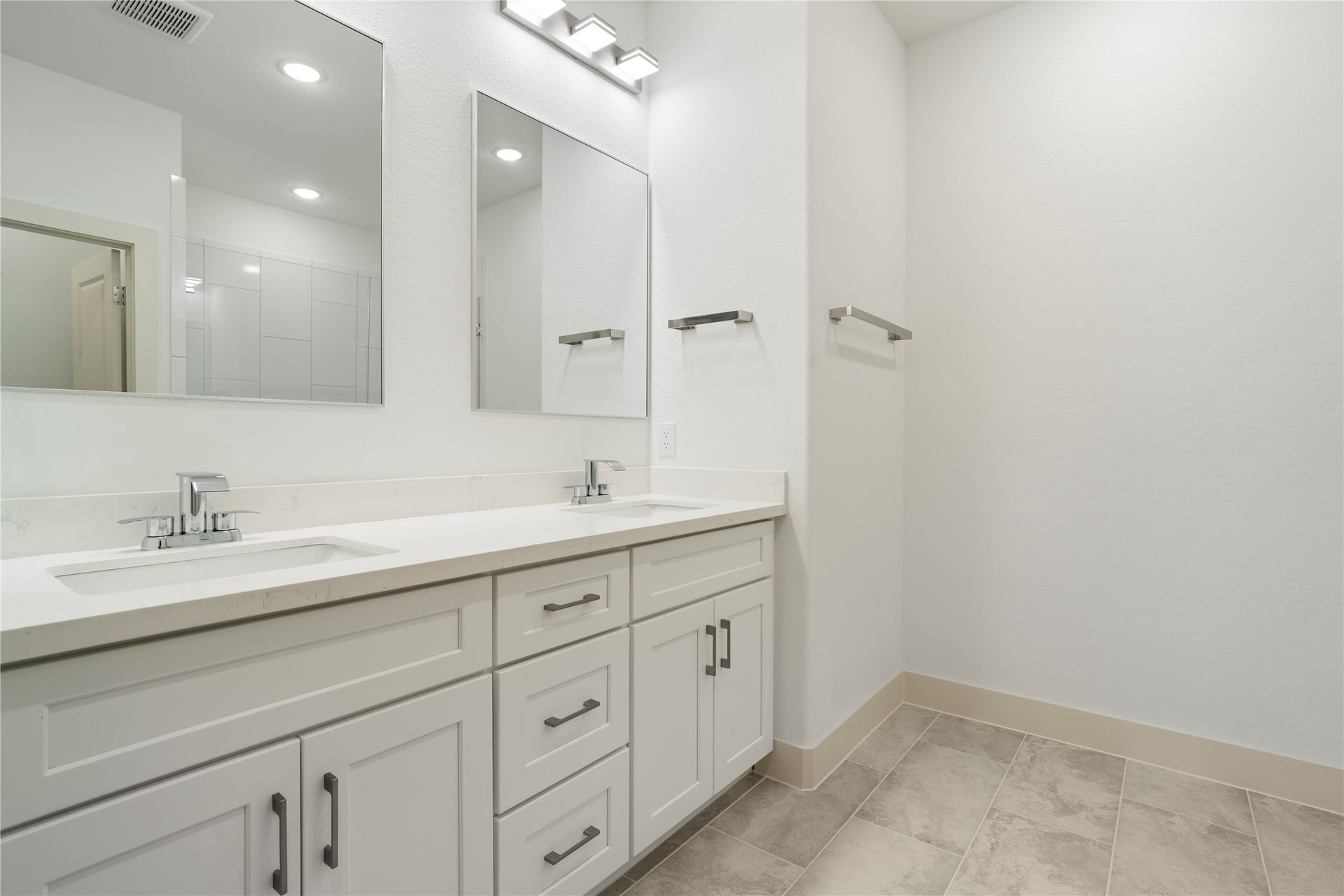 5629 Malmedy Road, Houston, TX 77033 Modern bathroom featuring a sleek dual-sink vanity with ample storage, complemented by elegant mirrors and contemporary fixtures.