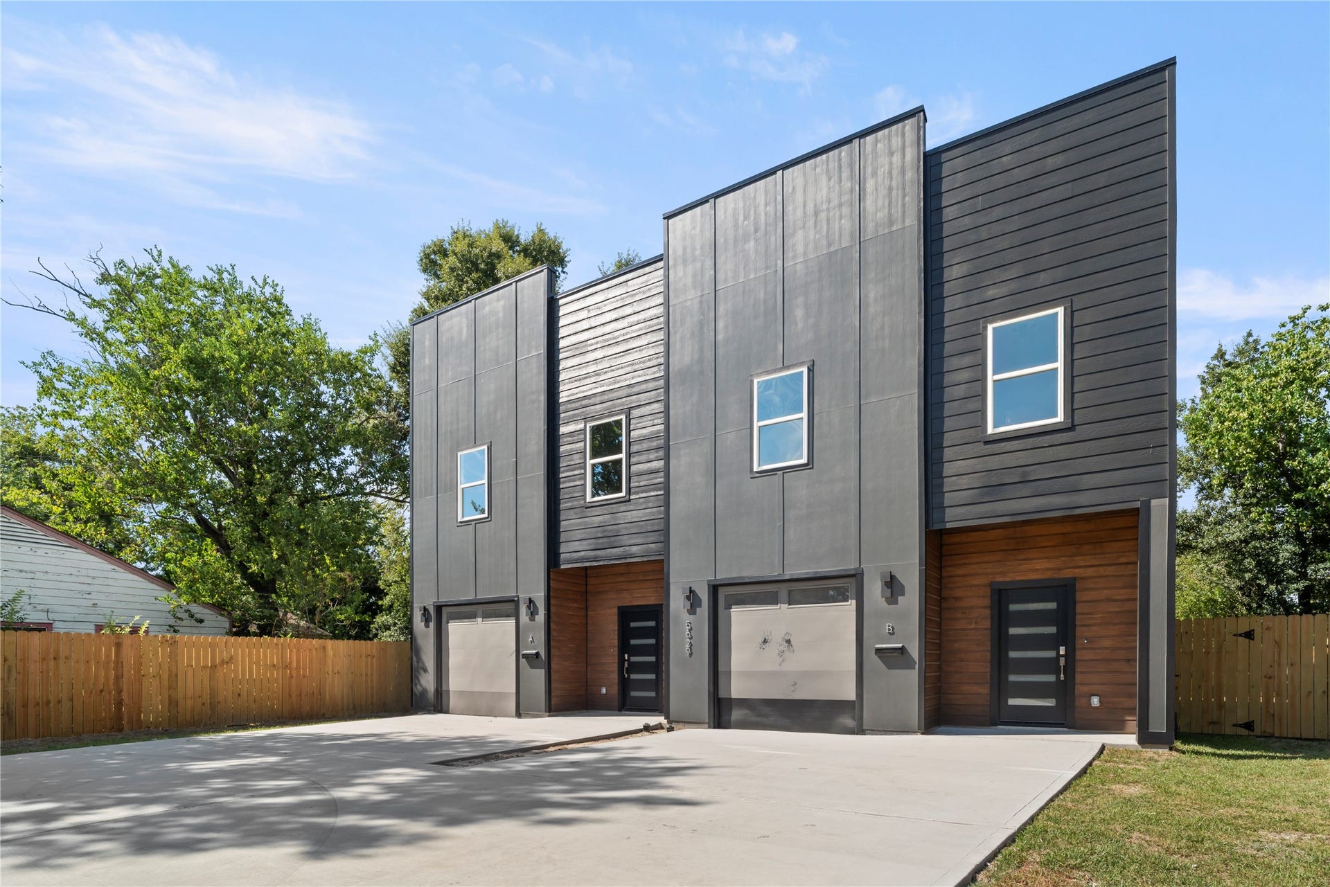 5629 Malmedy Road, Houston, TX 77033 Modern duplex with striking dark exterior, sleek lines, and large windows. Features spacious garage and private fenced yard, perfect for contemporary living.