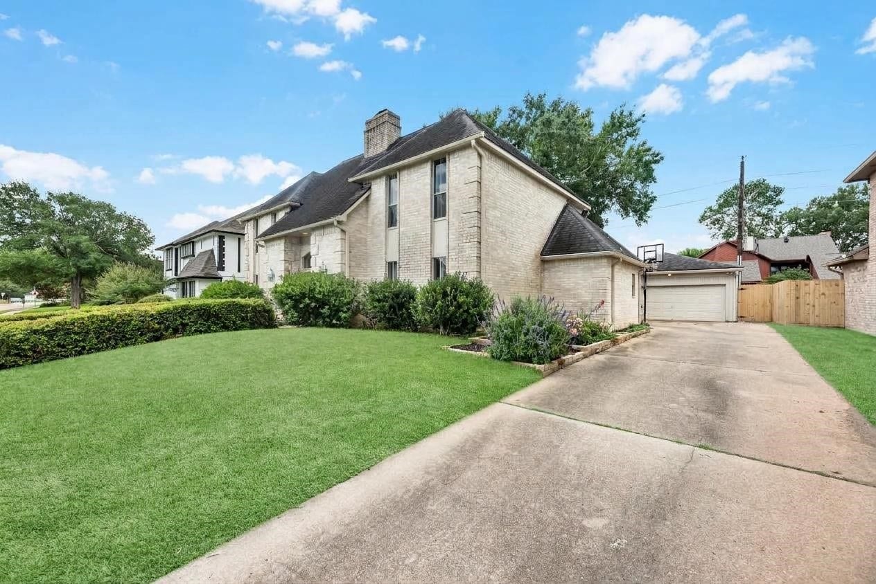 1523 Plantation Drive, Richmond, TX 77406 Front view of the home with expansive driveway and detached garage.