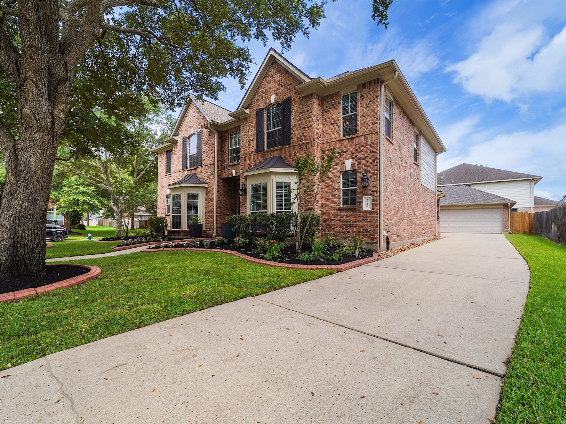 26214 Seminole Hill Lane, Katy, TX 77494 Fresh landscaping, mature shade trees, and timeless brick architecture create a warm welcome and lasting curb appeal.