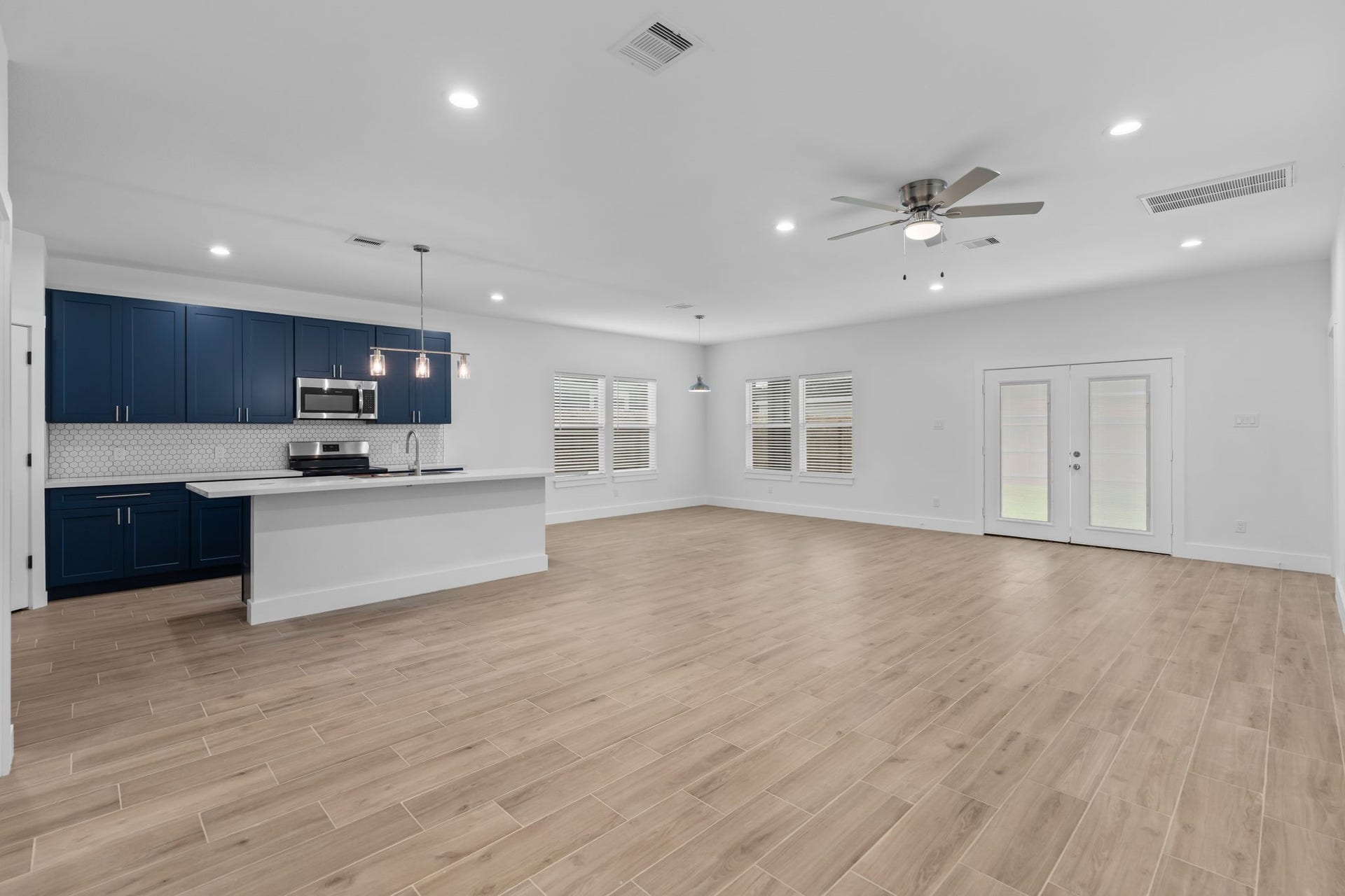 1303 Hawthorne Street, Baytown, TX 77520 Open-concept living with wood-look tile and recessed lighting throughout