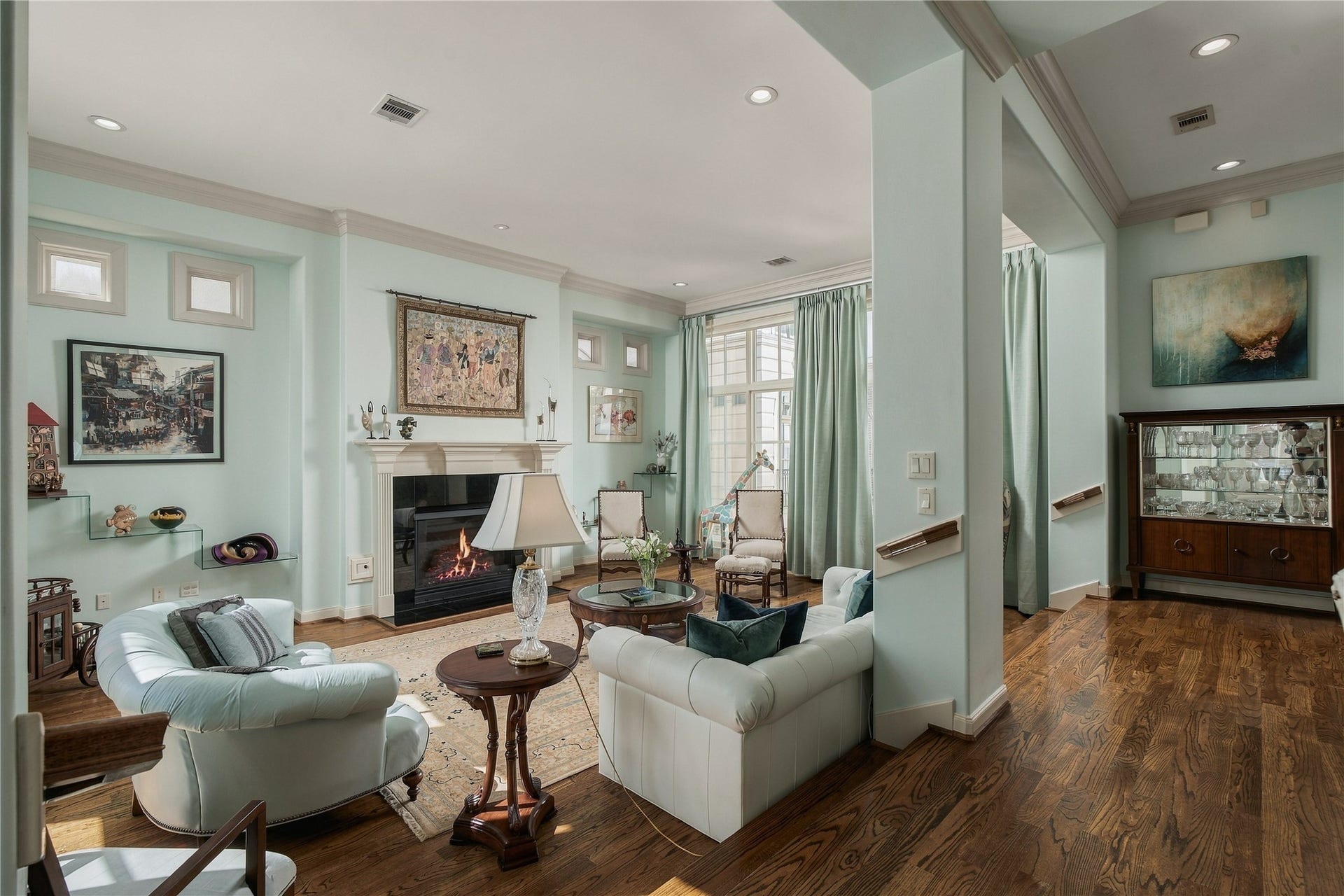 523 Lovett Boulevard, Houston, TX 77006 Arriving on the second floor, the home opens dramatically into its main living spaces, where tall windows, generous ceiling height and a fireplace establish an immediate sense of scale.