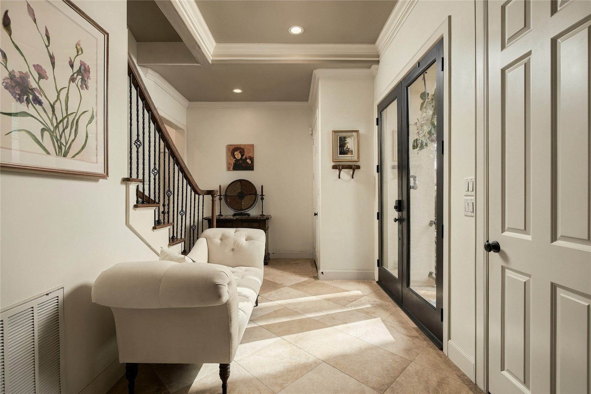 523 Lovett Boulevard, Houston, TX 77006 Step inside and the pace immediately changes. The entry feels warm and collected, with natural light coming through the glass doors and the staircase beginning the journey upward.