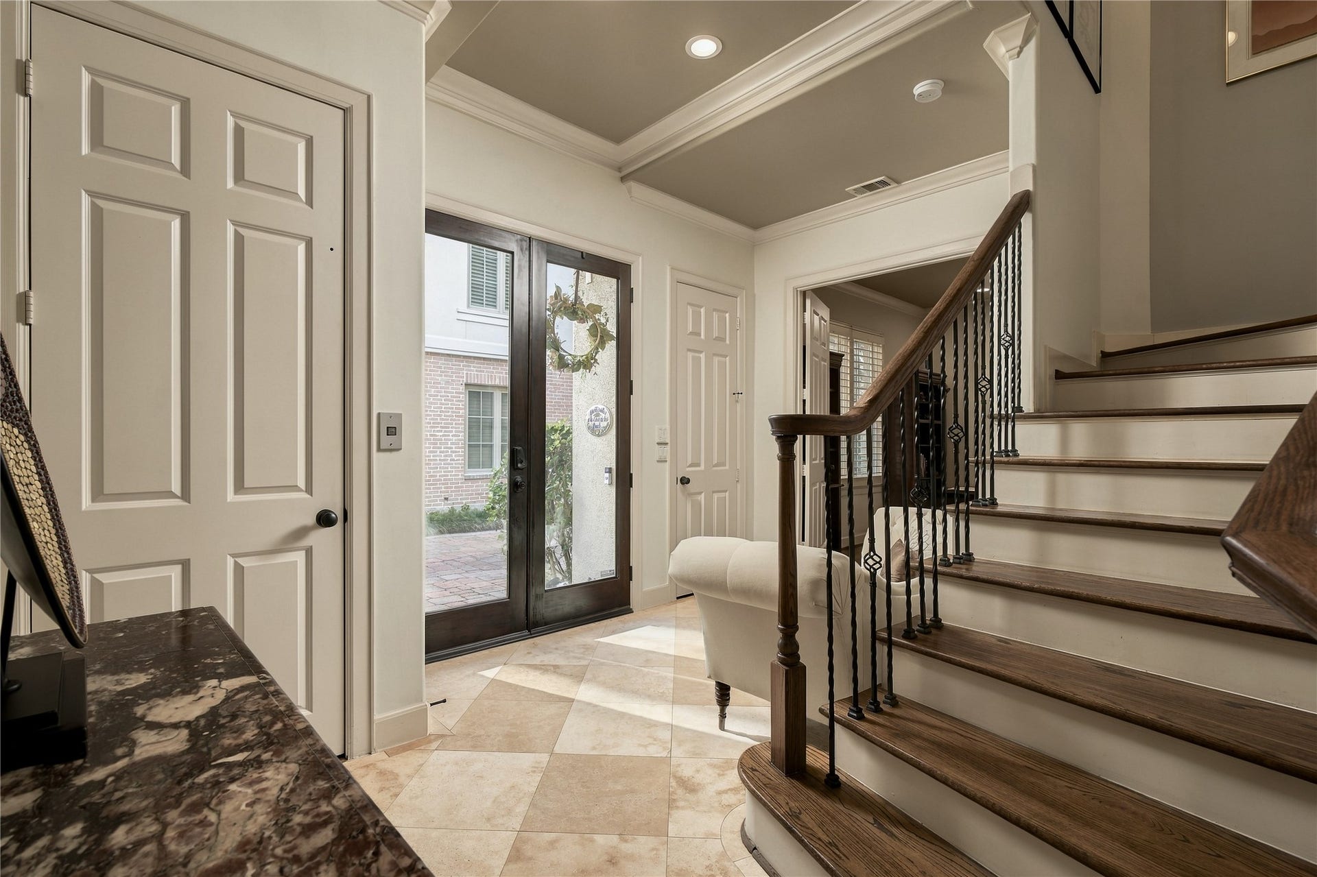 523 Lovett Boulevard, Houston, TX 77006 Back in the entry, the staircase becomes part of the architecture, pairing warm wood with iron detailing as the home begins to unfold vertically.