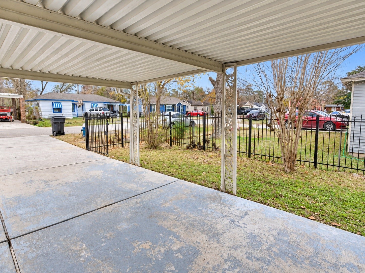 A fenced front yard with an iron gate