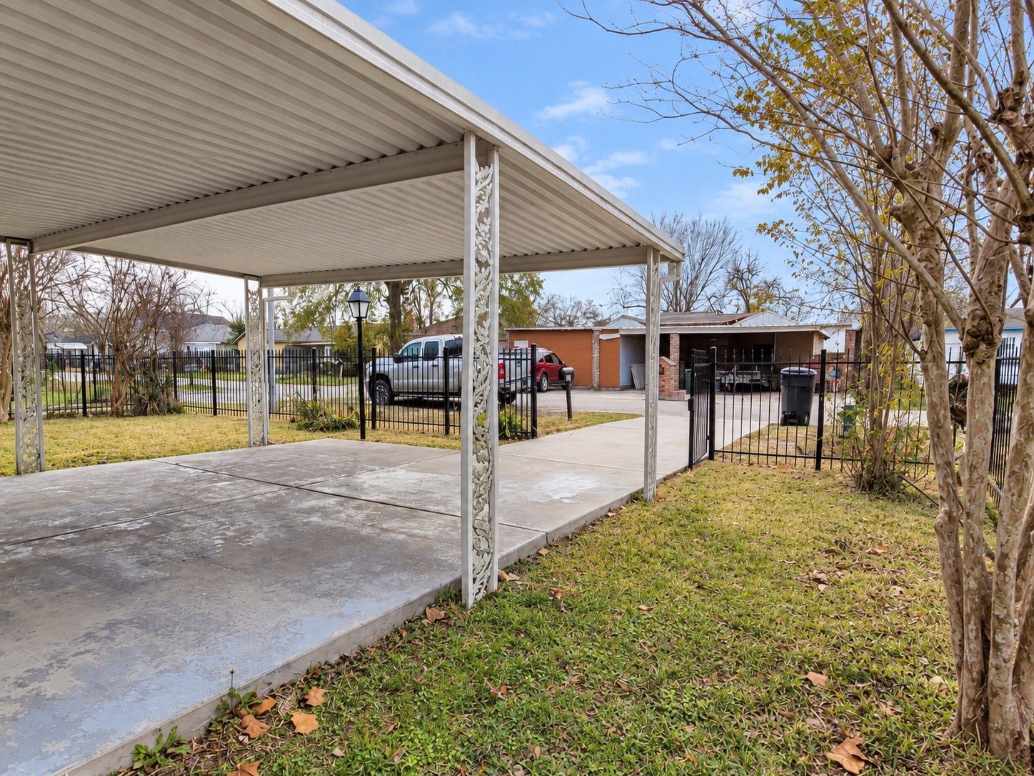 A long driveway with a covered carport.