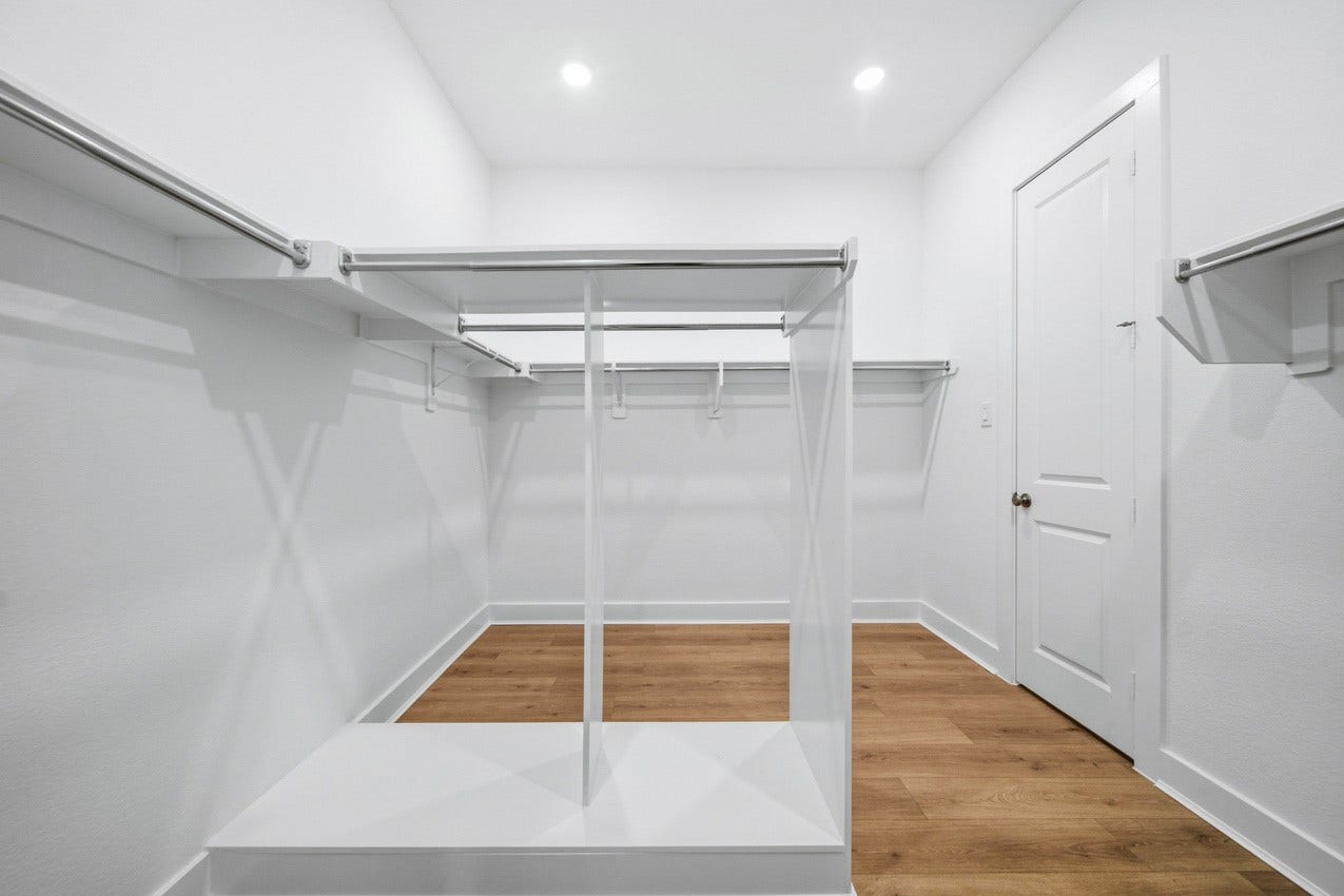 Expansive walk-in primary closet offering abundant storage and organization space.