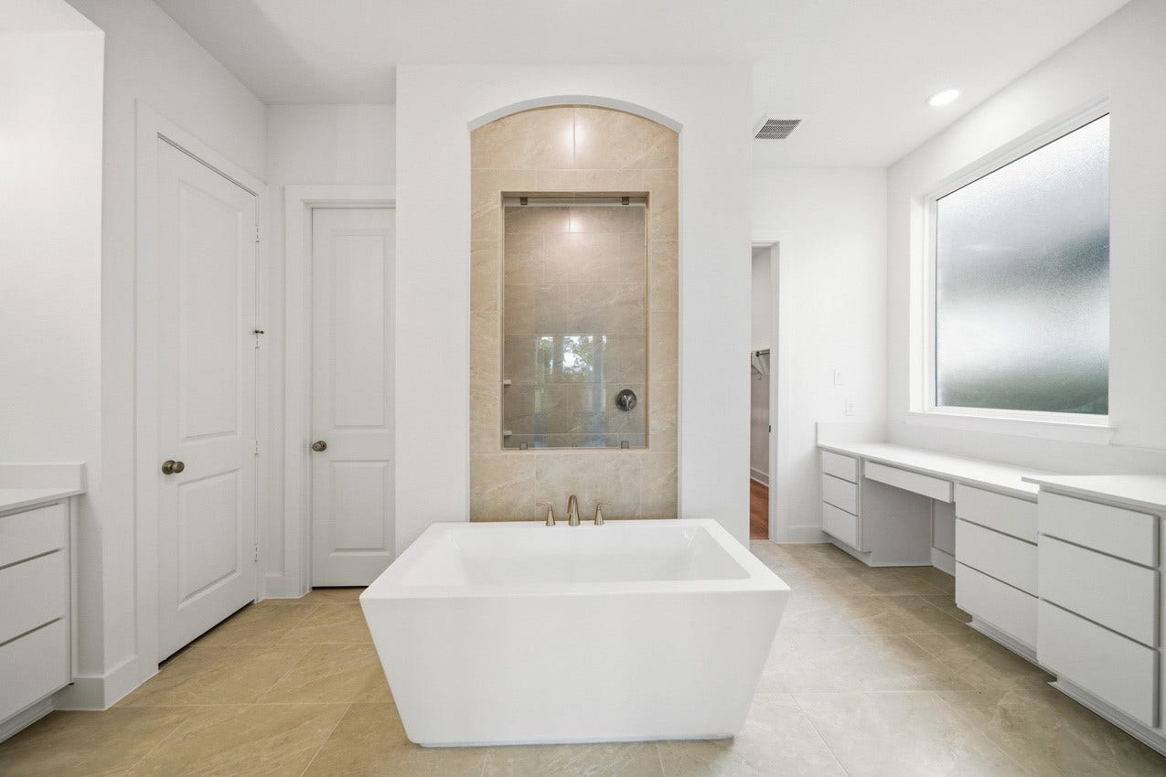 Luxurious primary bath featuring a freestanding soaking tub, oversized shower, and elegant finishes.