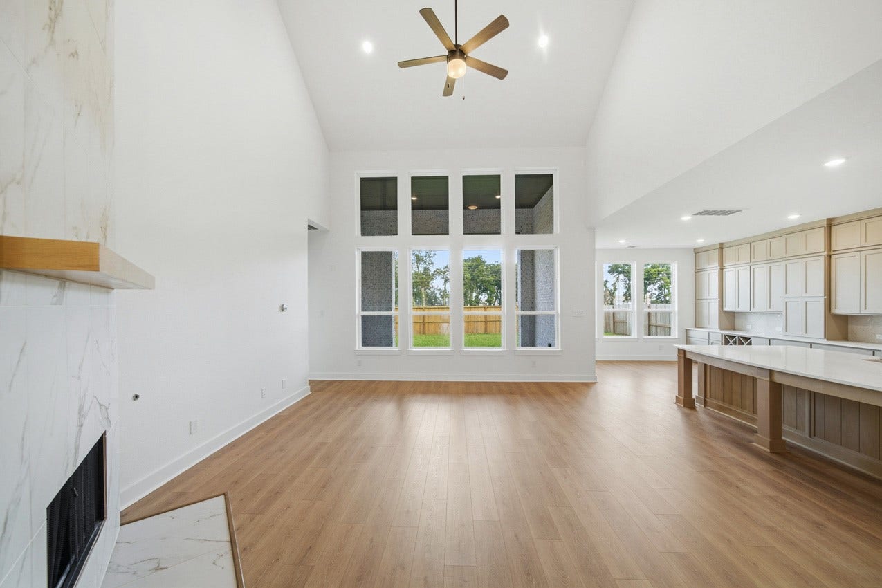 Wall of windows fills the open-concept family room with natural light and backyard views.