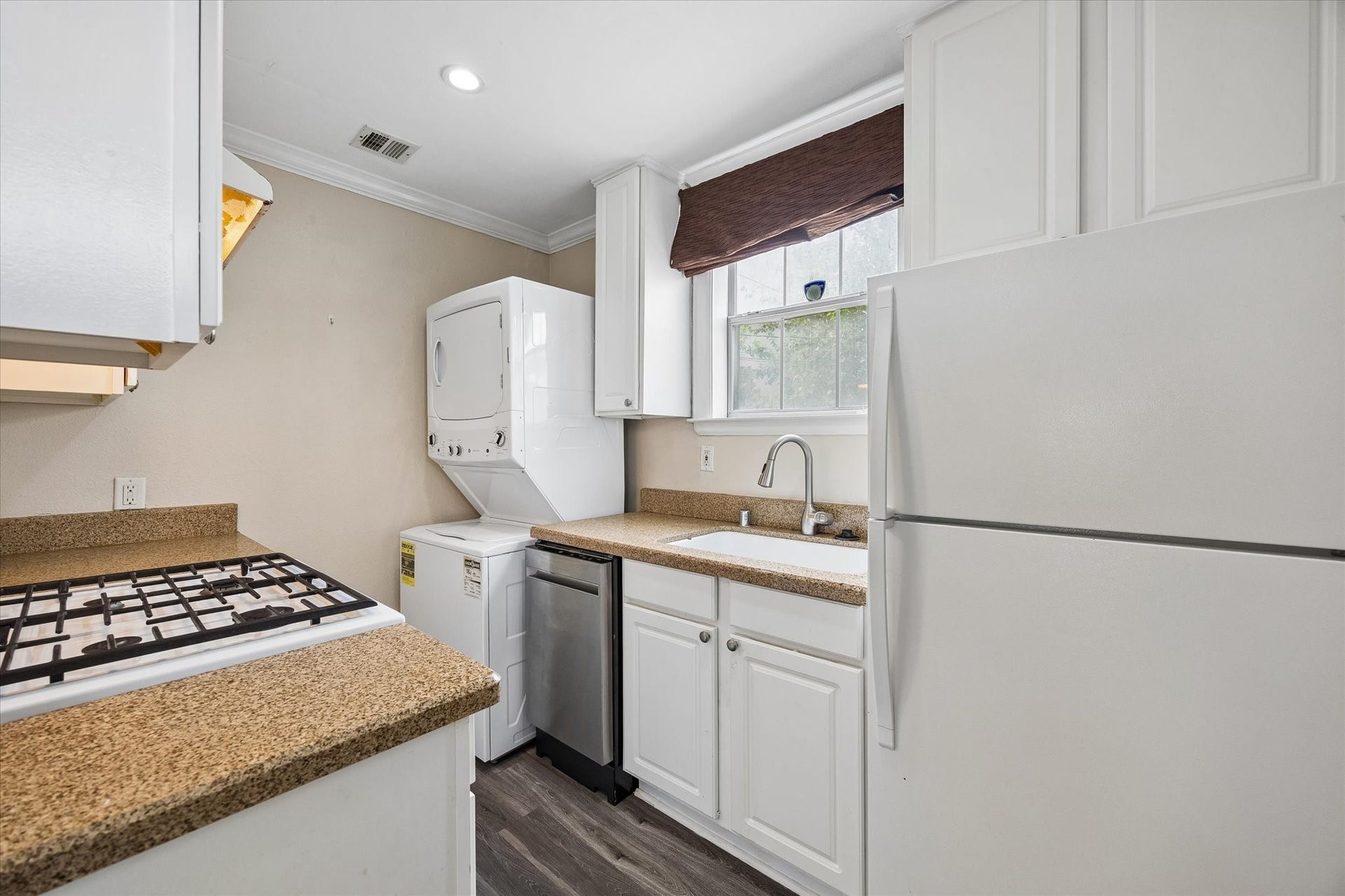 1020 Crocker Street, Houston, TX 77019 Charming kitchen with modern appliances, including a gas stove and stacked washer-dryer, complemented by ample cabinet space and natural light.