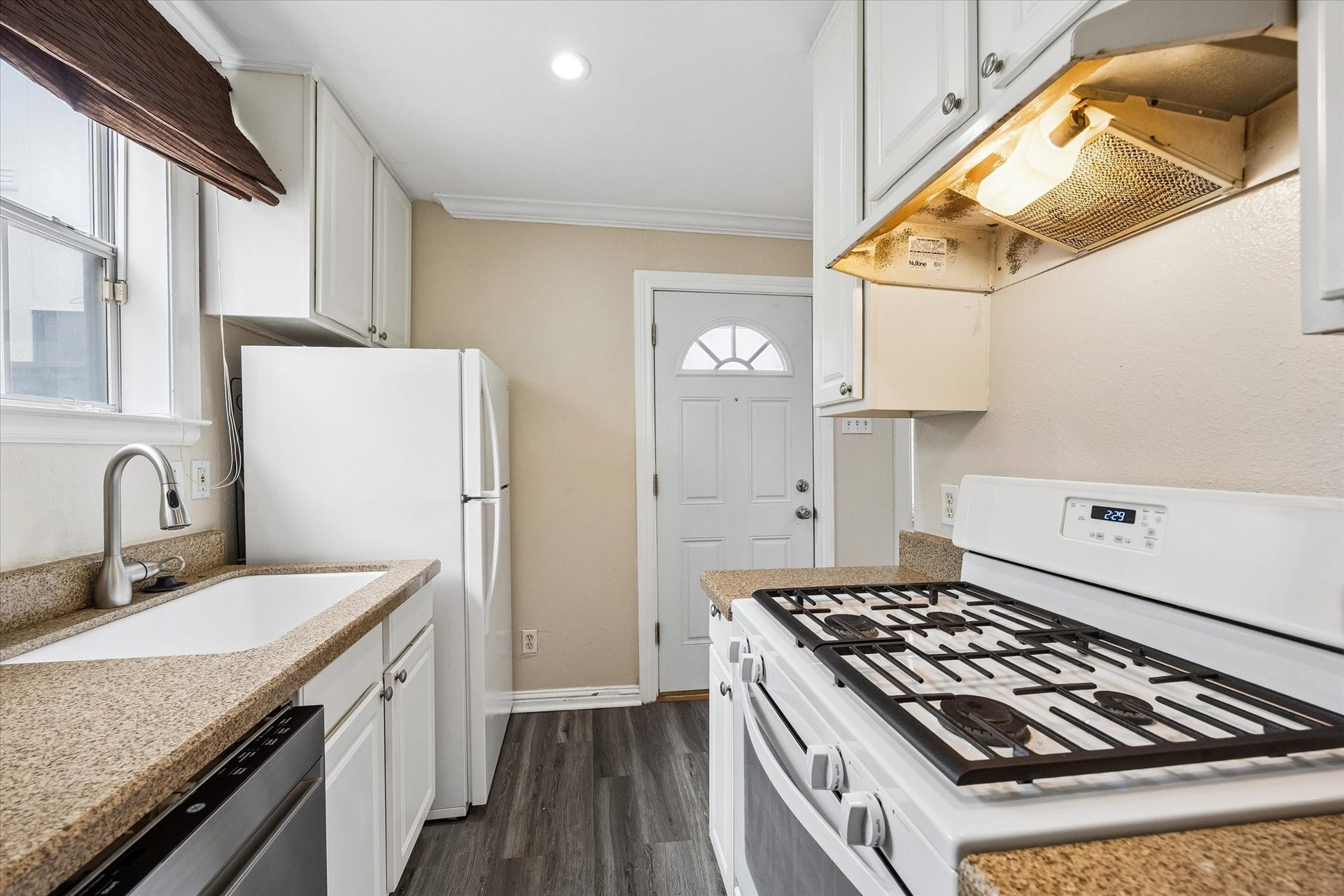 1020 Crocker Street, Houston, TX 77019 Charming kitchen with a gas stove, sleek countertops, and ample cabinetry, complemented by natural light from a nearby window.