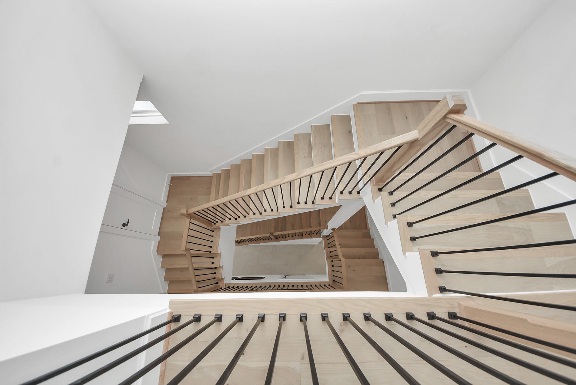 927 Fisher Street, #B, Houston, TX 77018 Ascend through this striking architectural moment, where a sculptural staircase becomes a design statement in itself. Warm wood treads contrast beautifully against crisp white walls, while sleek black railings guide your eye upward through the homes airy vertical space. Bathed in natural light from above, this staircase creates an elegant transition between levels, blending modern design with a sense of openness and flow.