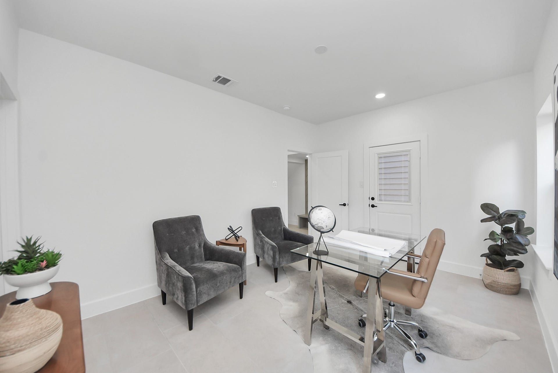 927 Fisher Street, #B, Houston, TX 77018 A dedicated home office completes the home, offering a clean, modern workspace with white walls, oversized windows, and contemporary furnishings. A glass-top desk and bold abstract artwork add a refined touch, making this room as inspiring as it is functional.