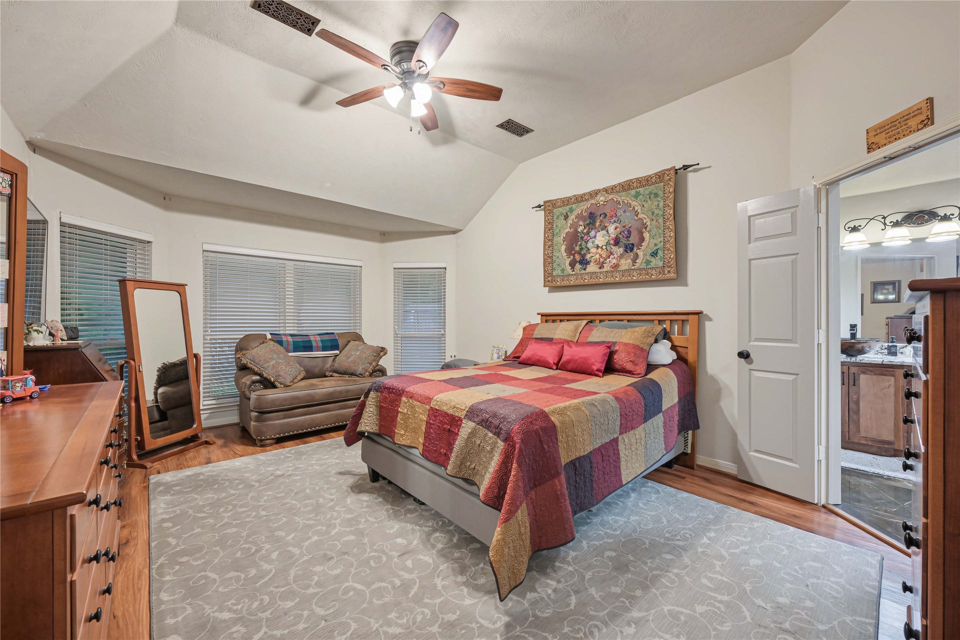 1918 Oakwood Court Drive, Baytown, TX 77521 Primary bedroom with bay windows, laminate floors, fan with light kit and beautiful en-suite bathroom