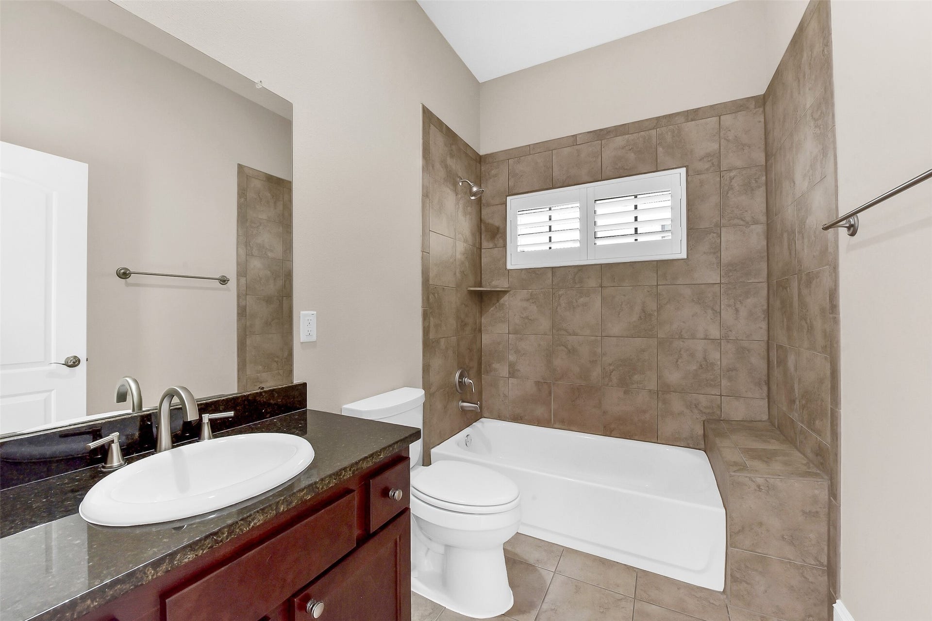 905 Garden Oaks Trace, Houston, TX 77018 Bathroom has tub/shower combination with tile surround and granite countertops.