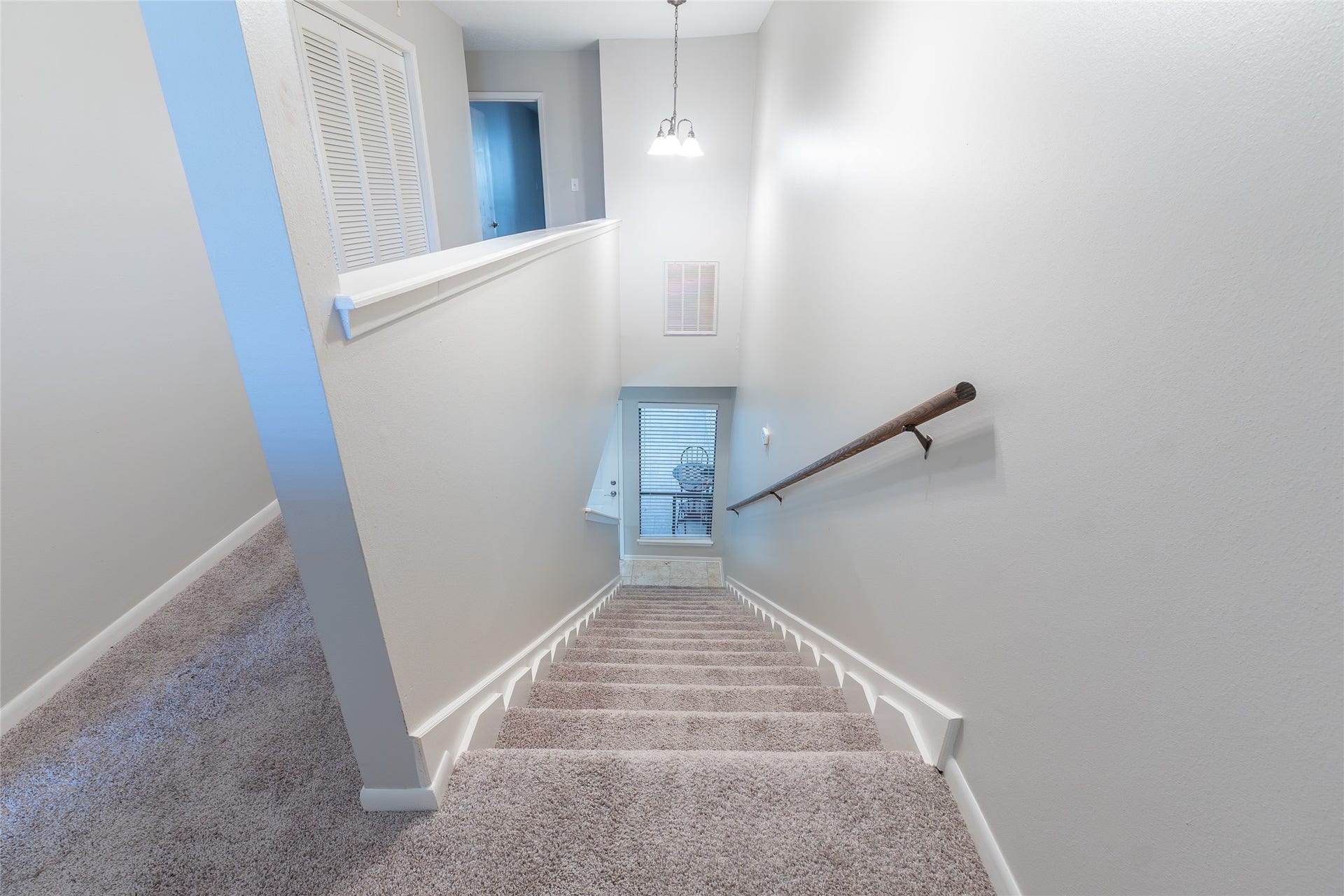 on the left: upstairs hallway, laundry room, door of third bedroom, on the right: stairs, door to flex room at the bottom of the stairs.