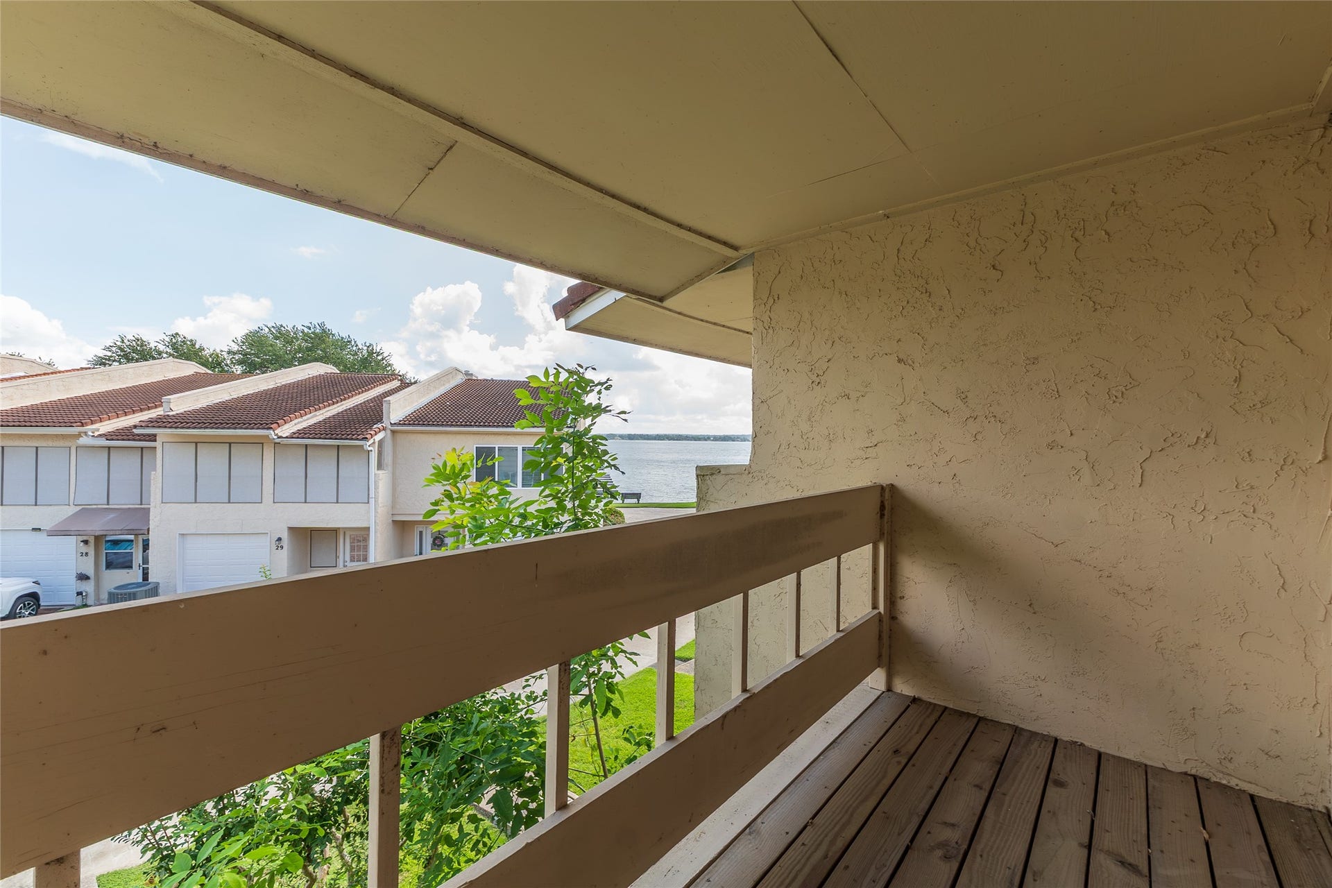 balcony outside the primary bedroom looking to the right. Lake is seen beyond