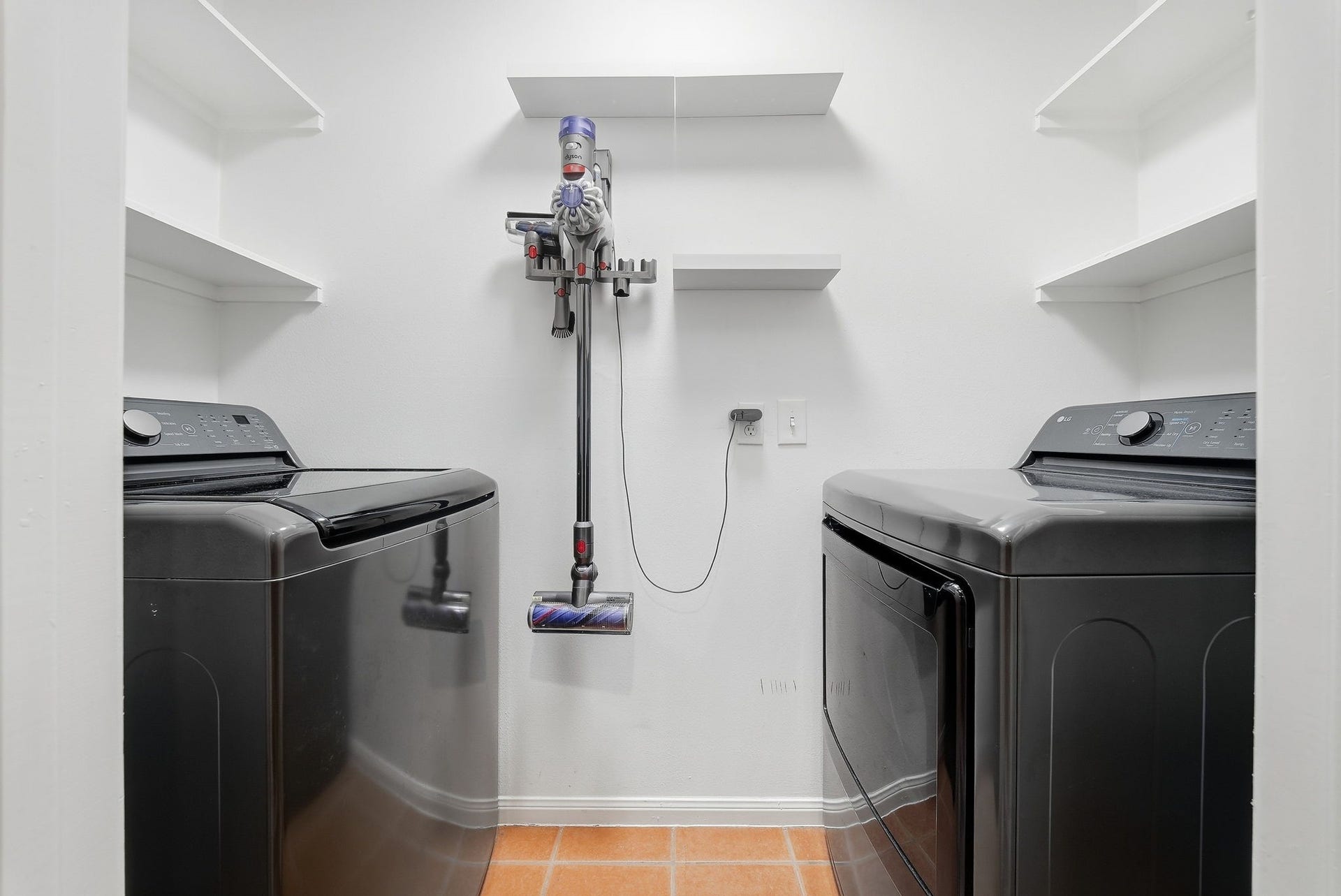 1917 Chapman Street, Houston, TX 77009 Utility room featuring washer and dryer with built-in storage shelving.
