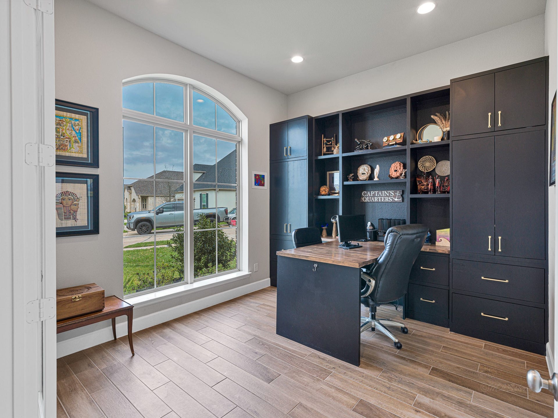 608 Malibu Pines Drive, Katy, TX 77493 The contemporary home office features custom built-in cabinets, shelving and desk, plus wood-look tile floors.