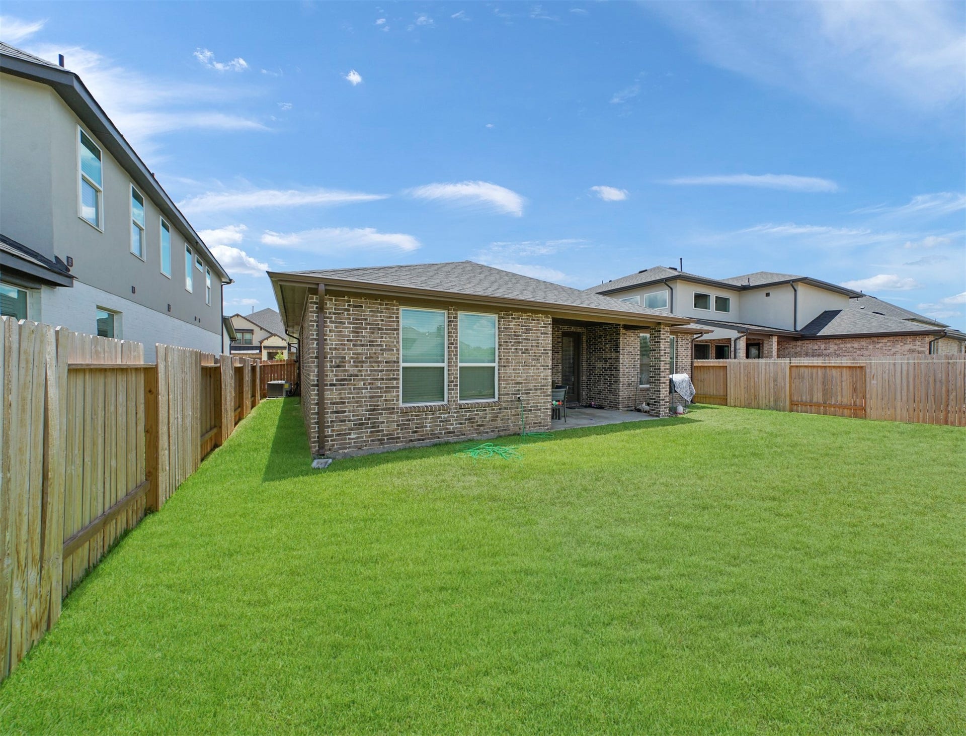 28226 Hazel Trail, Katy, TX 77494 The brick exterior carries around to the rear of the home, where a fenced side yard and generous green space surround the outdoor living area.