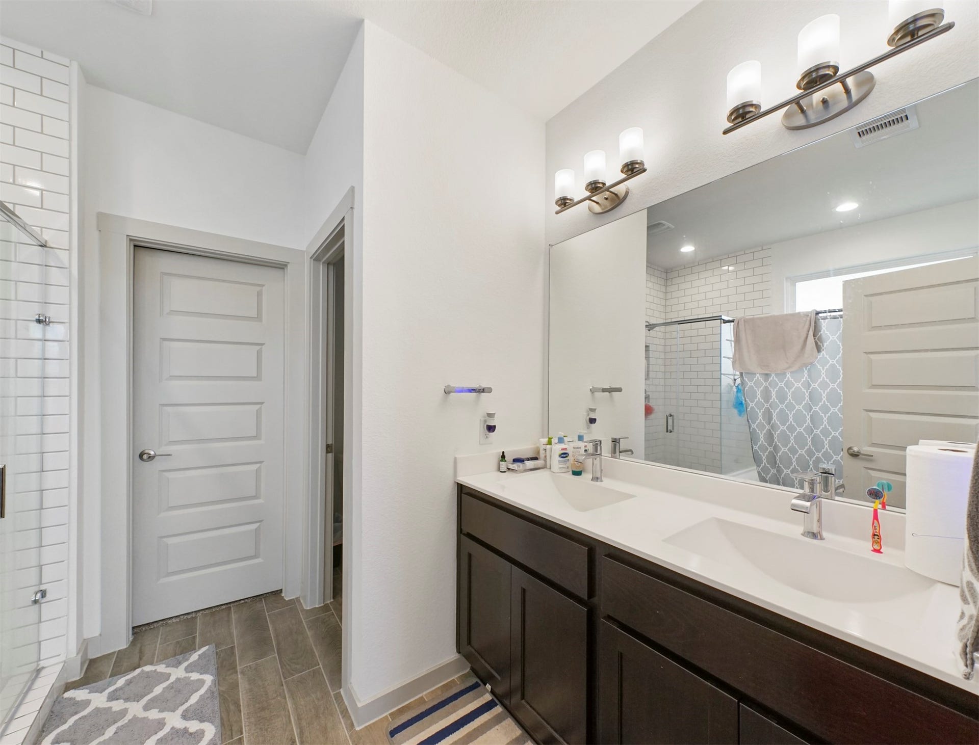 28226 Hazel Trail, Katy, TX 77494 The ensuite bath offers a double-sink vanity with espresso shaker cabinetry, white countertops, a wide mirror, and brushed nickel light fixtures.