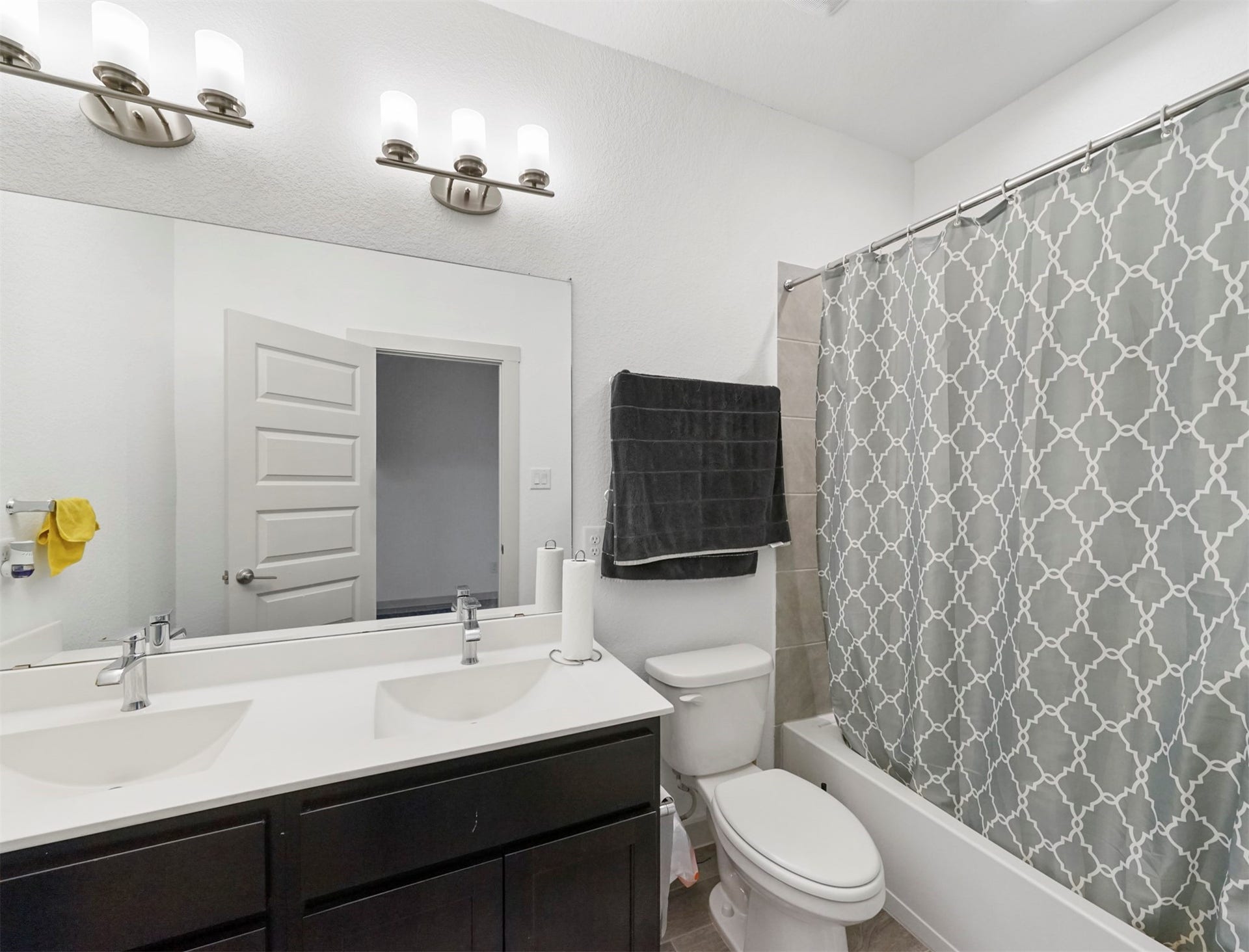 28226 Hazel Trail, Katy, TX 77494 The secondary bathroom offers a double-sink vanity with espresso cabinetry, sleek chrome fixtures, and a tub/shower combination with a tile surround.