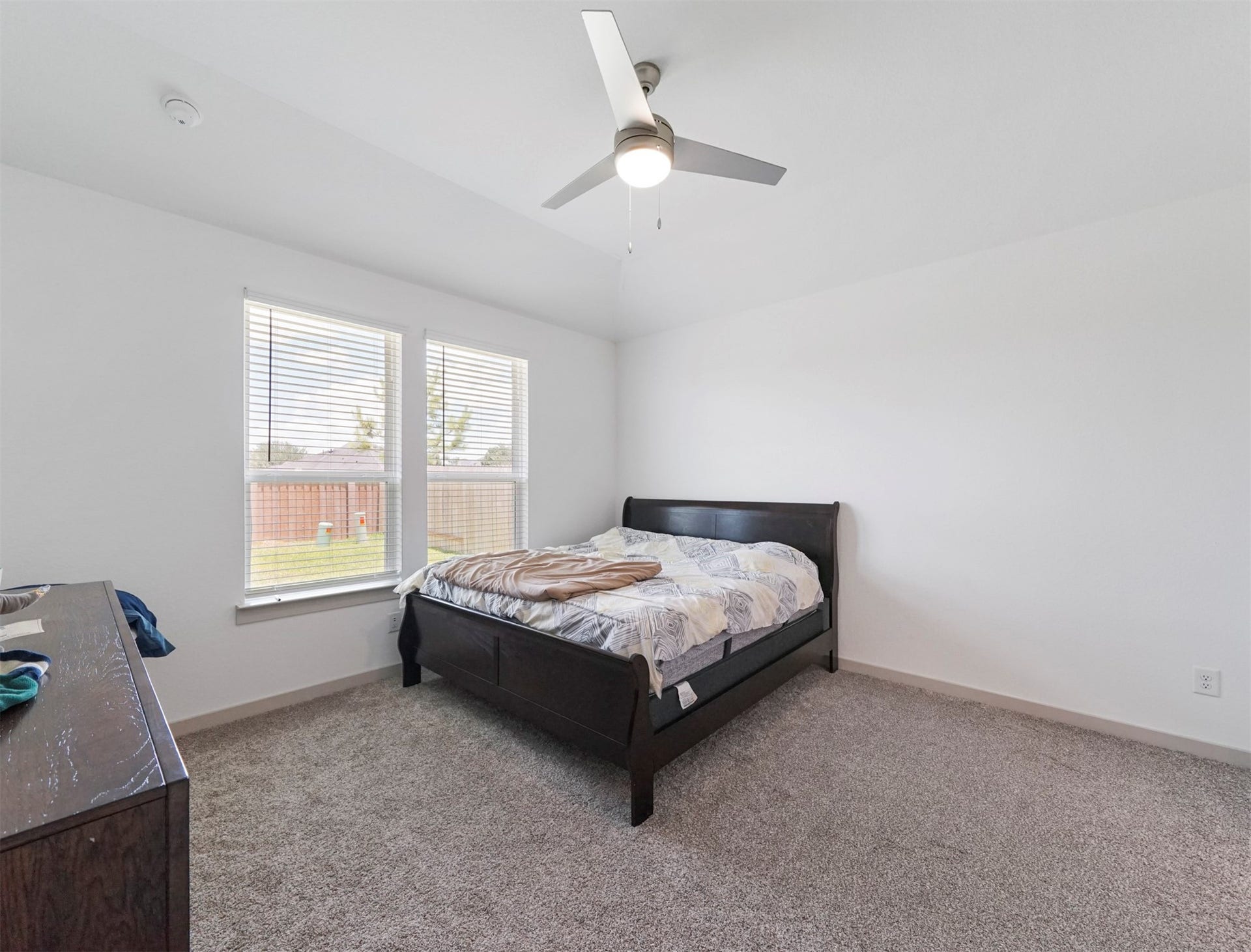 28226 Hazel Trail, Katy, TX 77494 The primary bedroom features plush carpet, a ceiling fan with light, and a pair of windows overlooking the backyard.