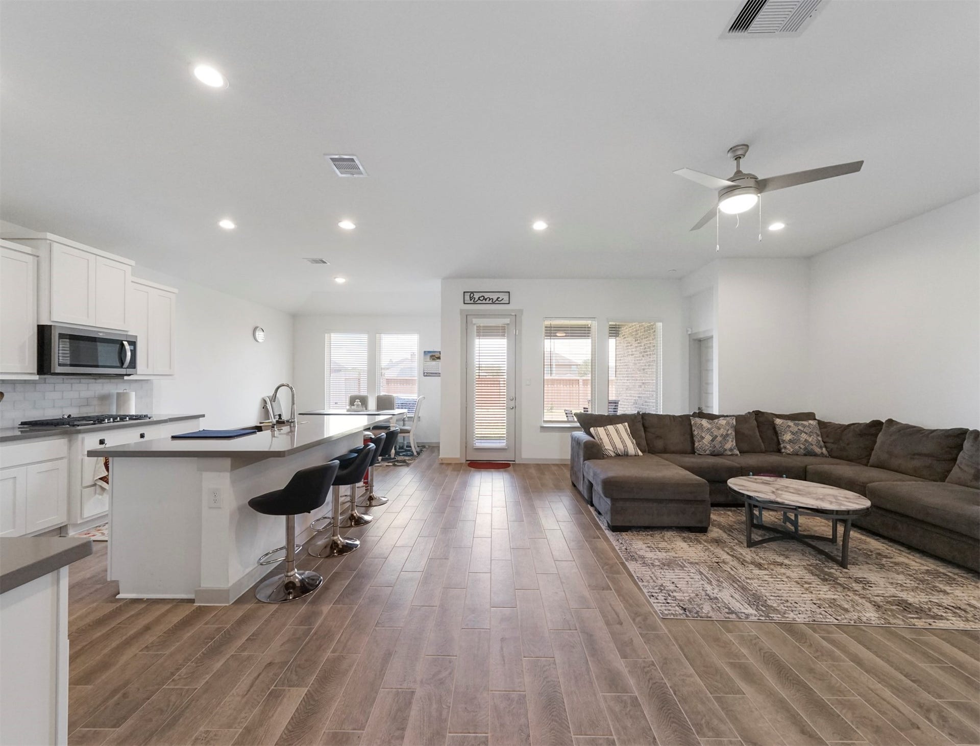 28226 Hazel Trail, Katy, TX 77494 An open layout connects the kitchen, dining area, and living room. Wood-look tile flooring runs throughout, with recessed lighting and a rear door to the backyard.