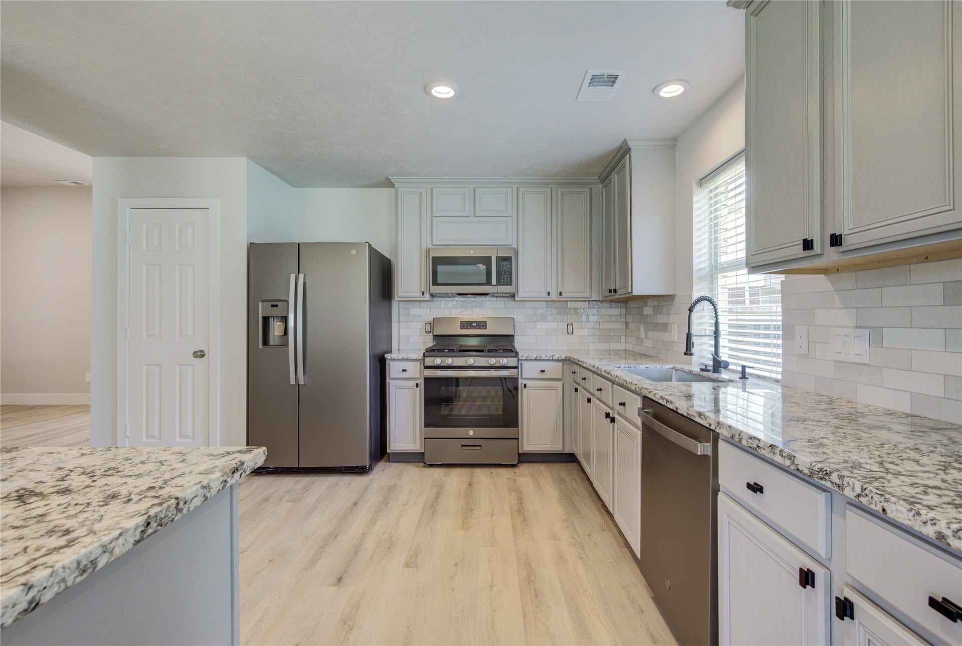 4931 Lake Catherine Court, Richmond, TX 77407 The beautifully renovated kitchen offers abundant cabinet storage, expansive granite countertops, subway tile backsplash and a large breakfast bar perfect for everyday living and entertaining
