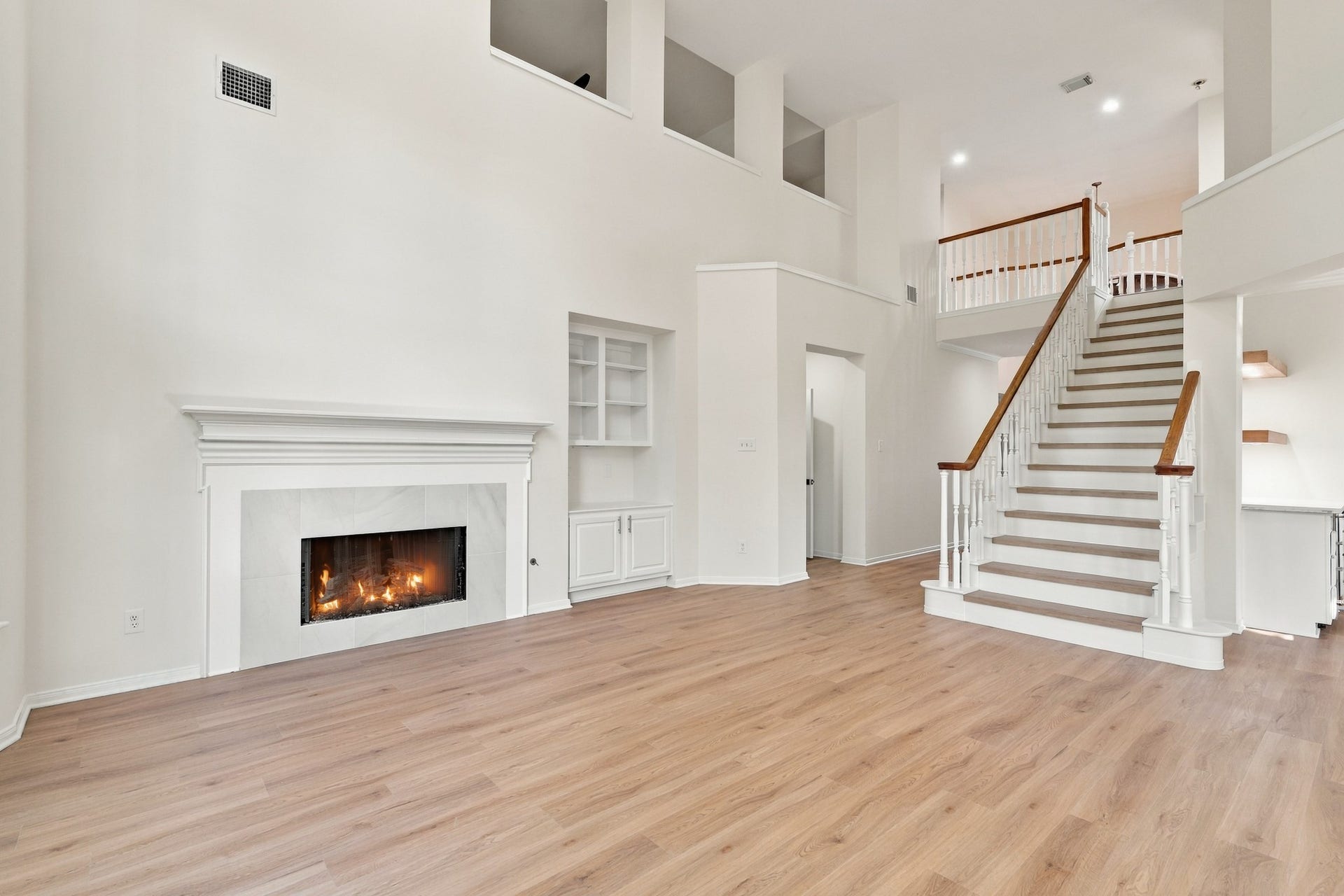 1931 Auburn Trail, Sugar Land, TX 77479 Spacious living area featuring a cozy fireplace, elegant staircase, and open layout with abundant natural light.