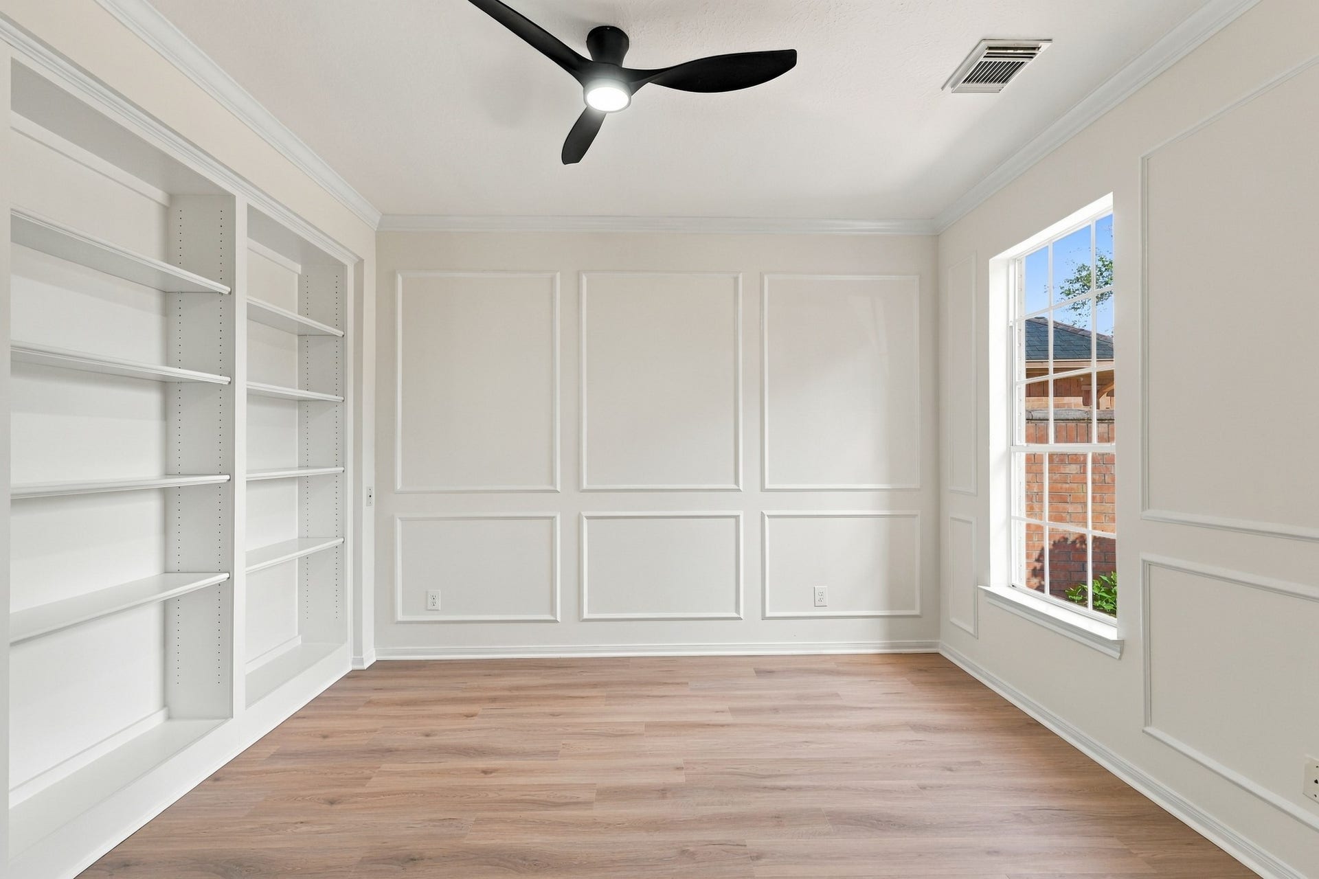 1931 Auburn Trail, Sugar Land, TX 77479 Bright and inviting room with elegant wainscoting, built-in shelving, and a large window offering abundant natural light.