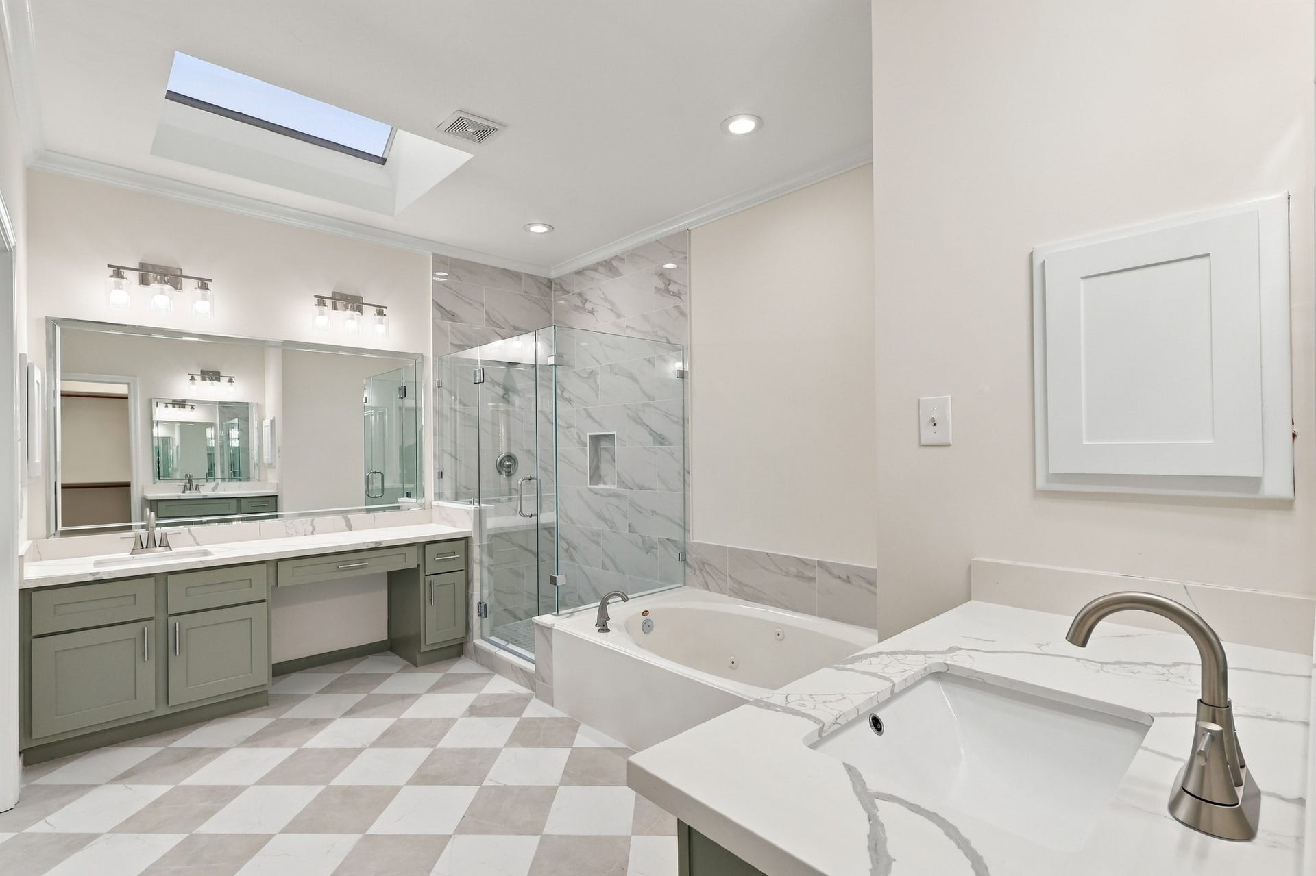 1931 Auburn Trail, Sugar Land, TX 77479 Spacious and elegant bathroom featuring a luxurious soaking tub, glass-enclosed shower, dual vanities with ample counter space, and a skylight for natural lighting.