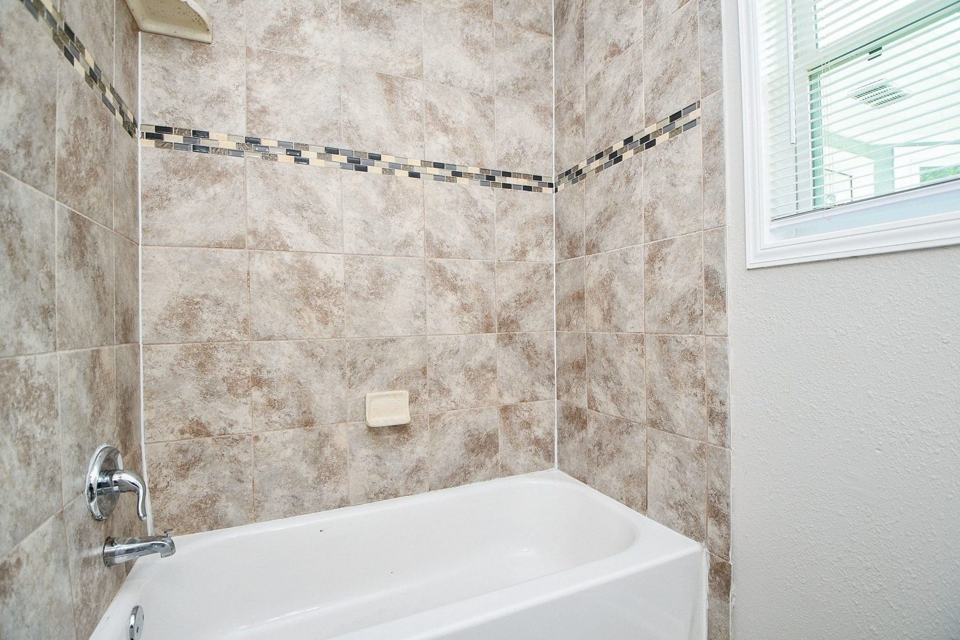 922 Bacliff Drive, Bacliff, TX 77518 Bath and shower combo with easy to clean tile and accents makes this shower pop.