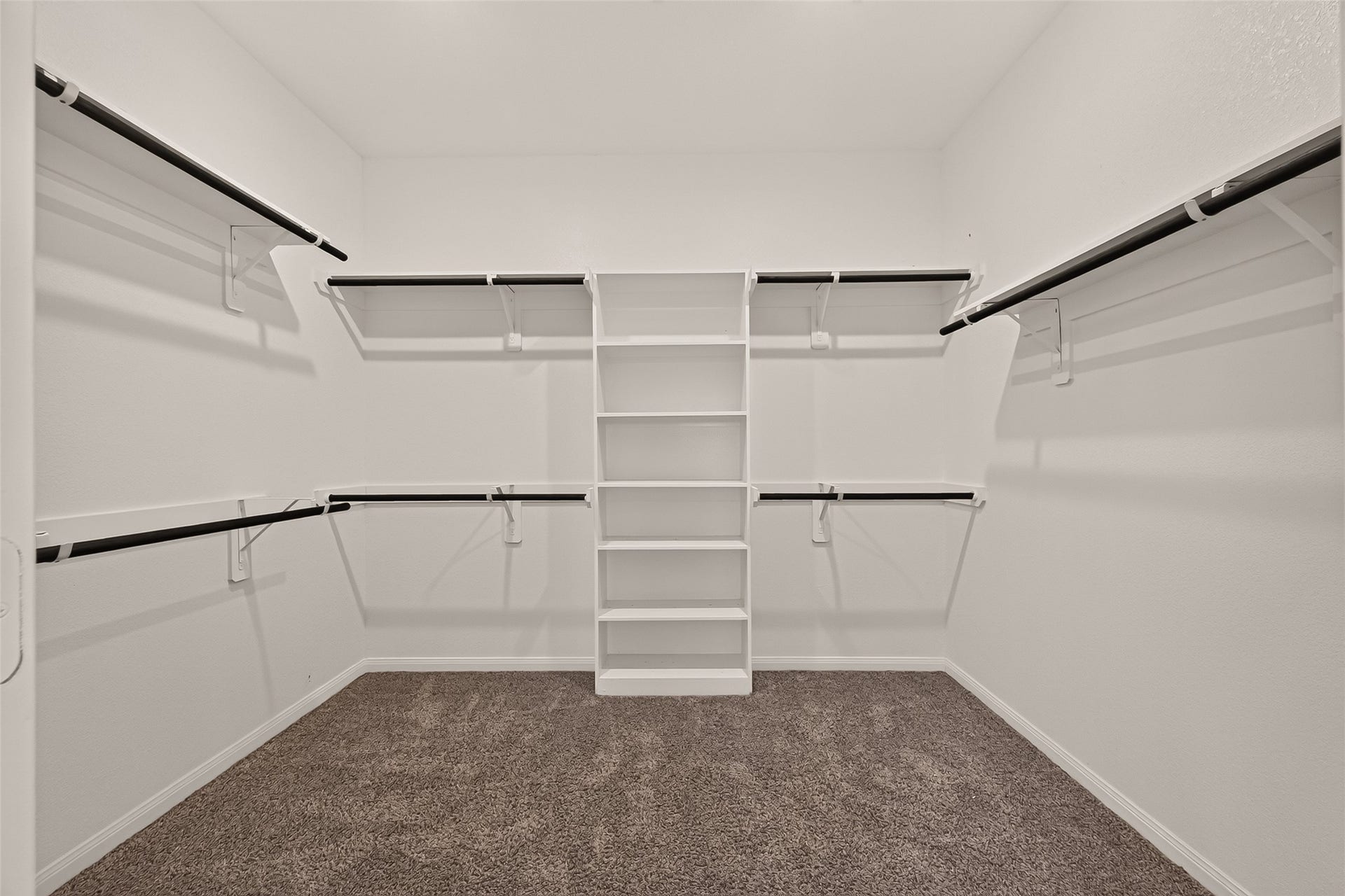 Spacious walk-in closet featuring ample shelving and hanging space for organized storage.