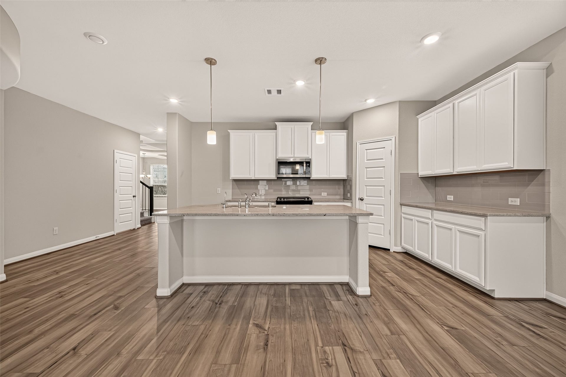 Sleek and modern kitchen featuring elegant granite countertops and a spacious center island for ultimate functionality.