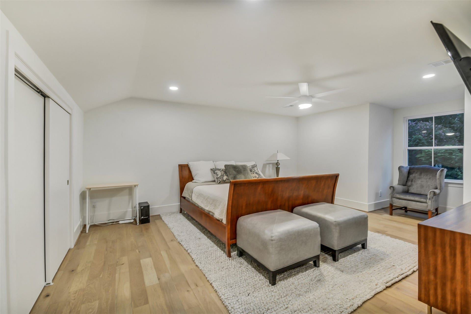 9411 Millbury Drive, Houston, TX 77096 A spacious upstairs bedroom with vaulted ceilings, a large closet, and a bright window seating area. Light wood flooring and generous proportions offer plenty of room for both sleeping and lounging space.