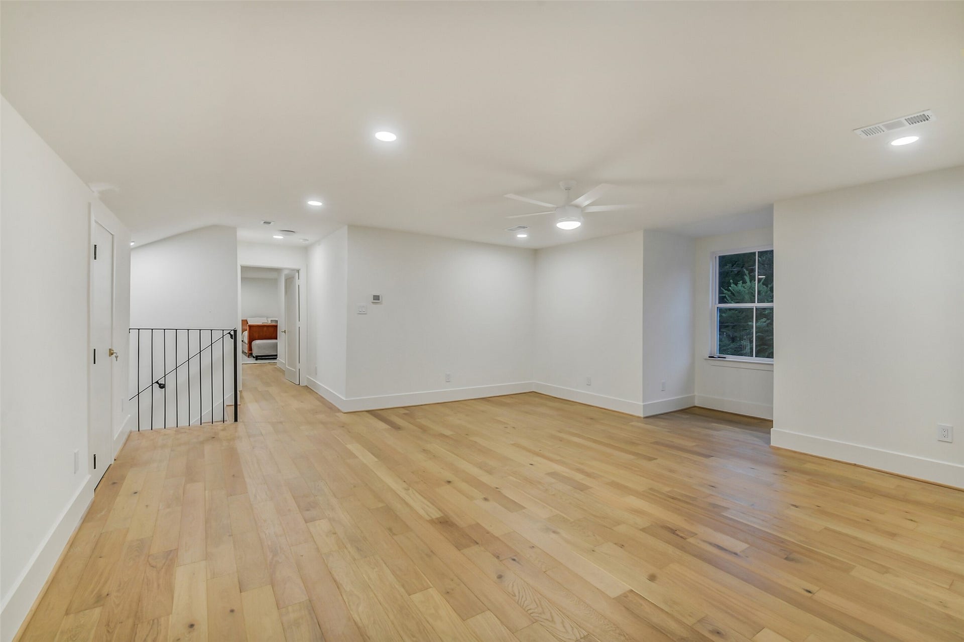 9411 Millbury Drive, Houston, TX 77096 A spacious upstairs living area, ideal as a game room, media space, or additional lounge. Wood flooring, a ceiling fan, and a bright window keep the space light-filled, with easy access to the bedrooms and staircase down to the main level.