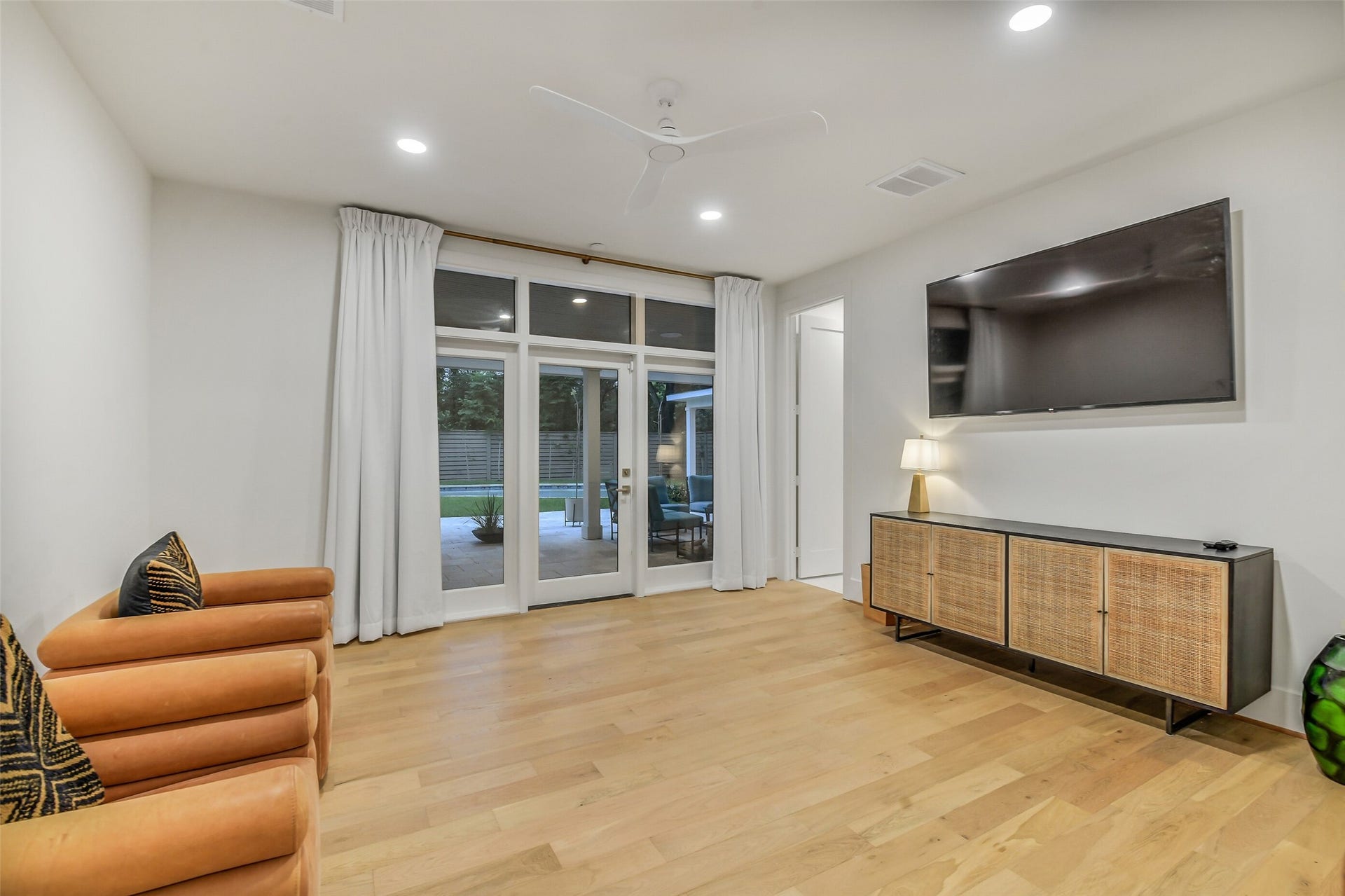 9411 Millbury Drive, Houston, TX 77096 A bright, versatile bedroom with French doors opening directly onto the backyard and pool, offering seamless indoor-outdoor access. Light wood flooring, a ceiling fan, and generous space complete this comfortable retreat.
