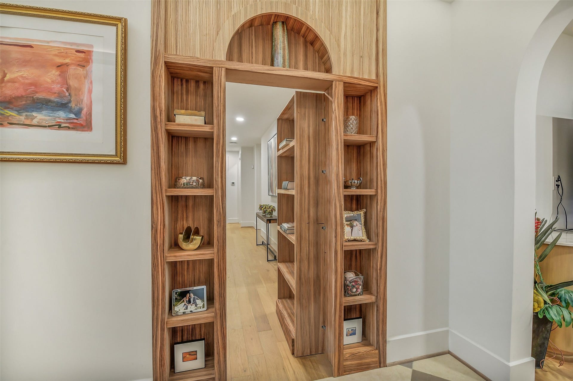 9411 Millbury Drive, Houston, TX 77096 A one-of-a-kind custom rotating wood bookshelf conceals the private bedroom wing, creating a striking hidden doorway that blends craftsmanship, style, and functionality. This unique architectural feature offers an unforgettable transition from the main living spaces to the home's private retreat.