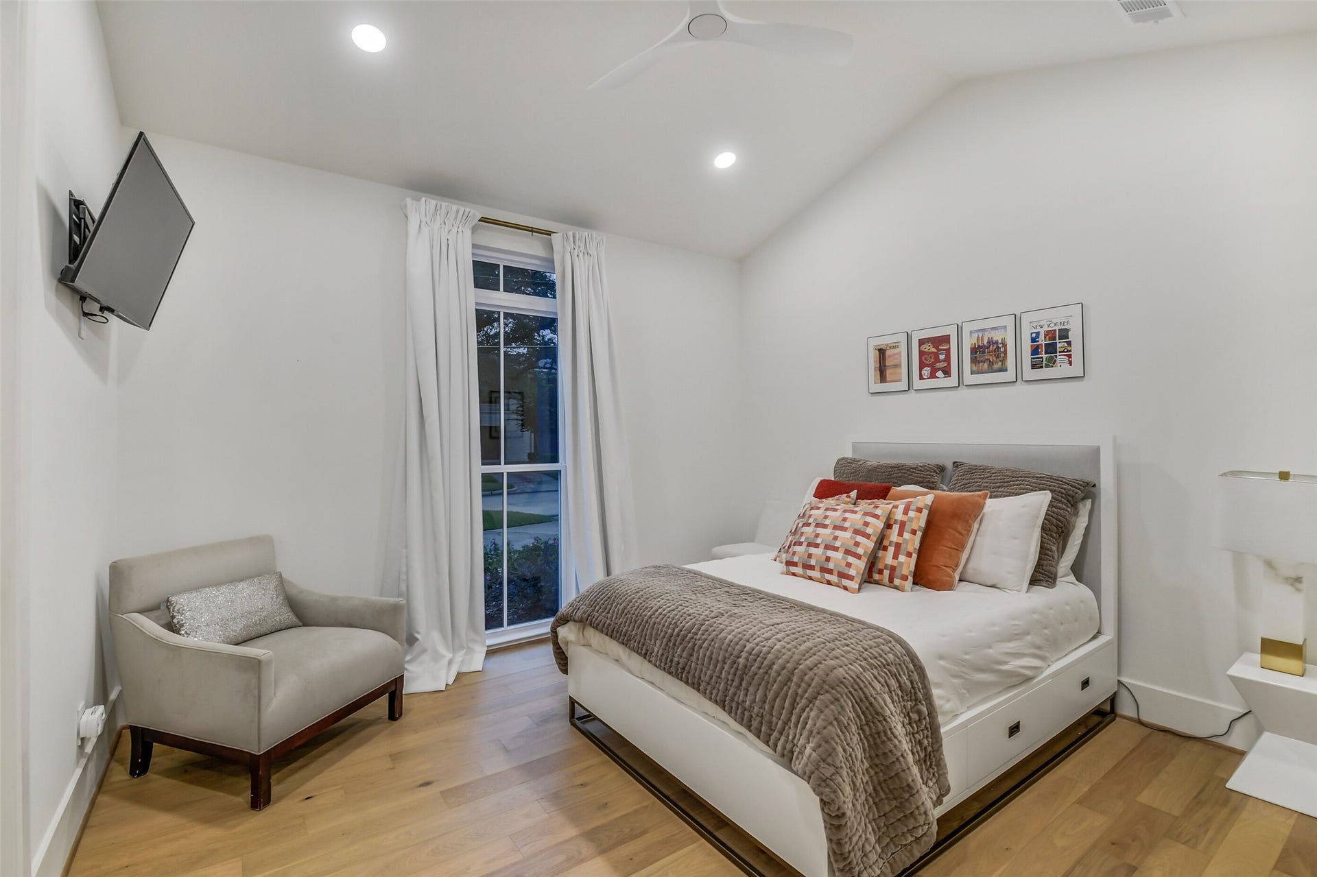 9411 Millbury Drive, Houston, TX 77096 A bright, comfortable bedroom featuring a vaulted ceiling and a large window with natural light each secondary bedroom offers its own distinct ceiling design, adding character throughout the home.