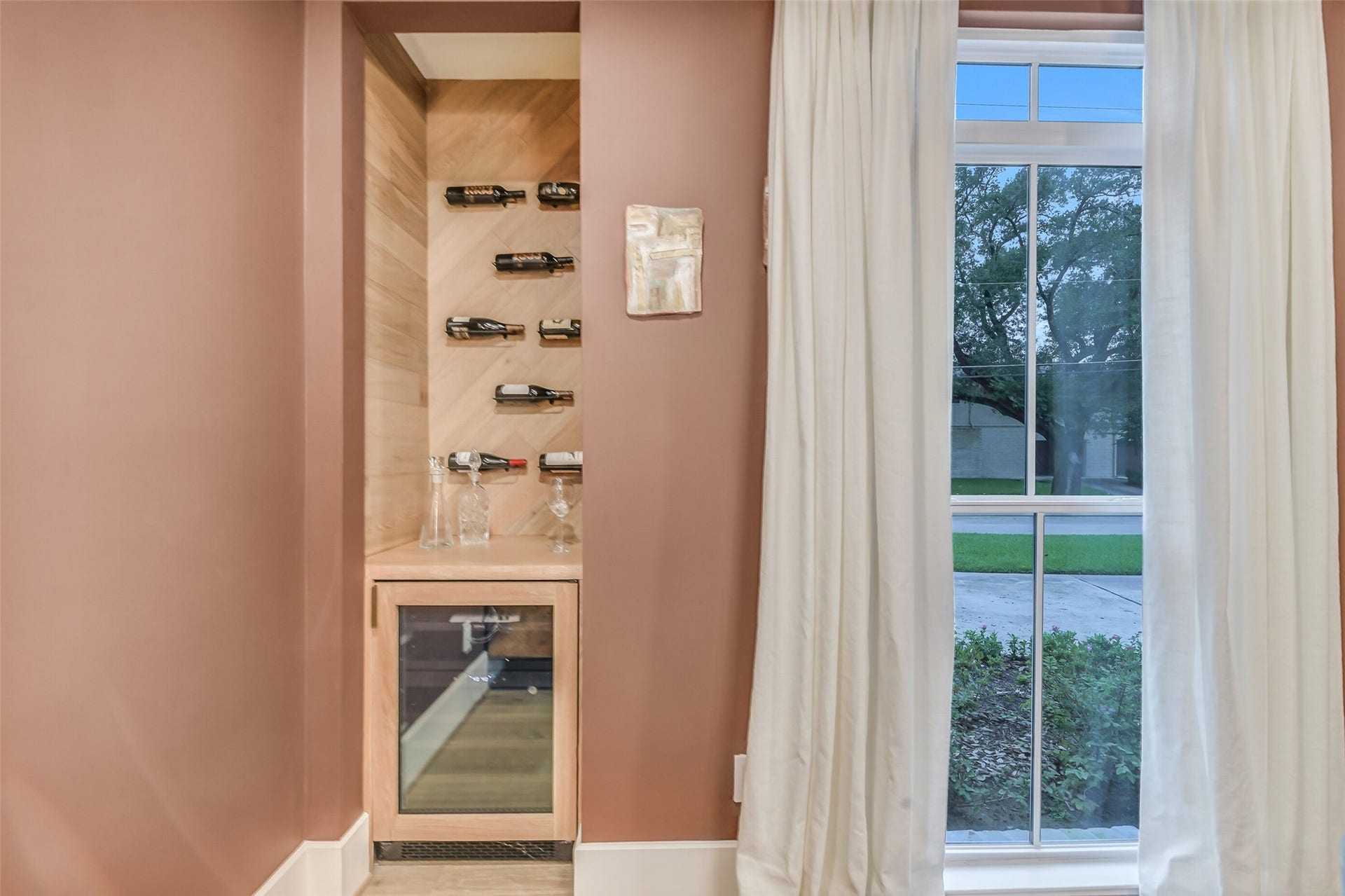 9411 Millbury Drive, Houston, TX 77096 A custom wine display niche with wood-paneled walls and sleek bottle racks sits just off the dining room, complete with a built-in wine fridge for effortless entertaining.