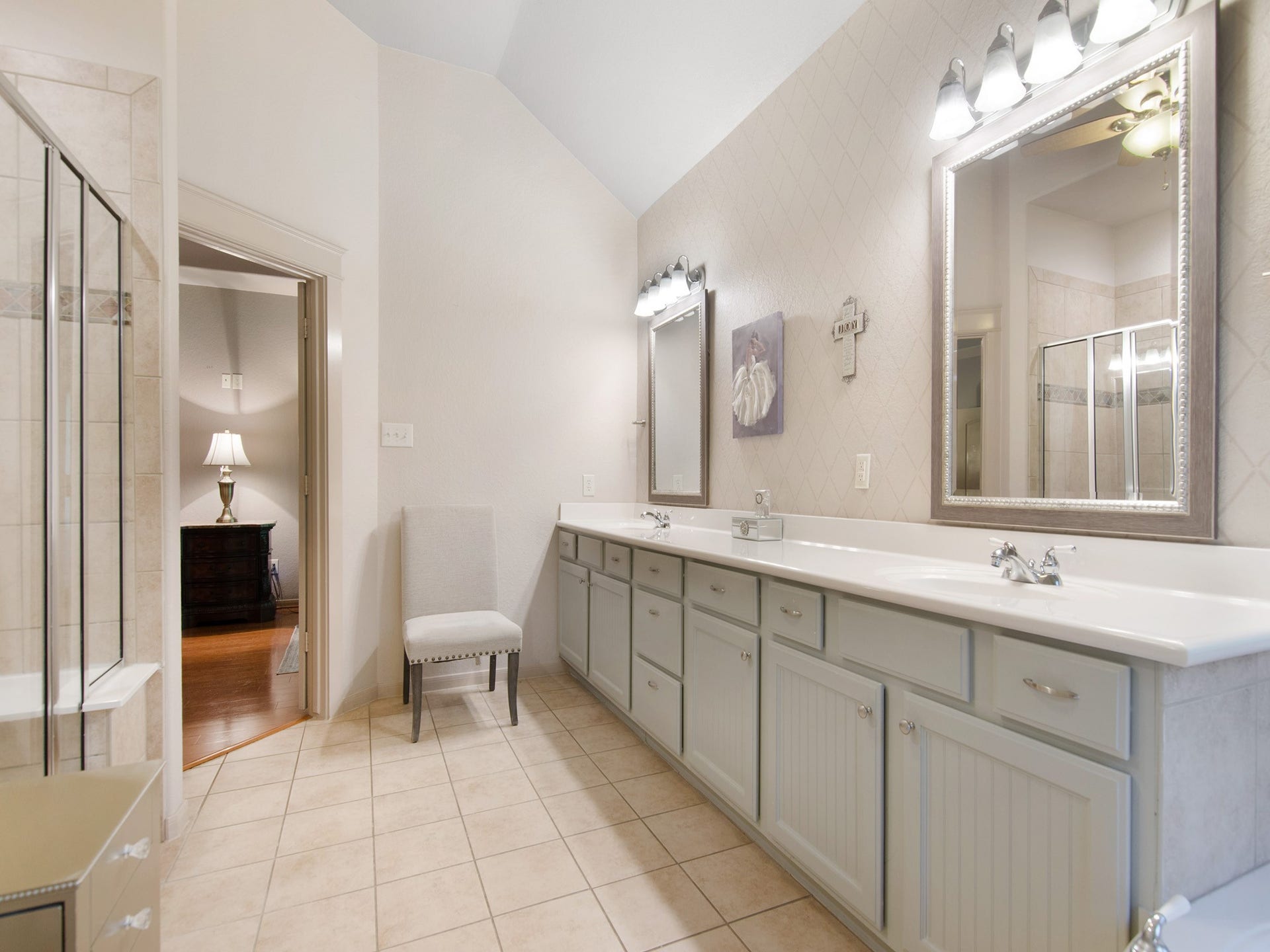 A large his-and-her vanity offers extensive counter space and storage, providing a functional layout designed for busy mornings.