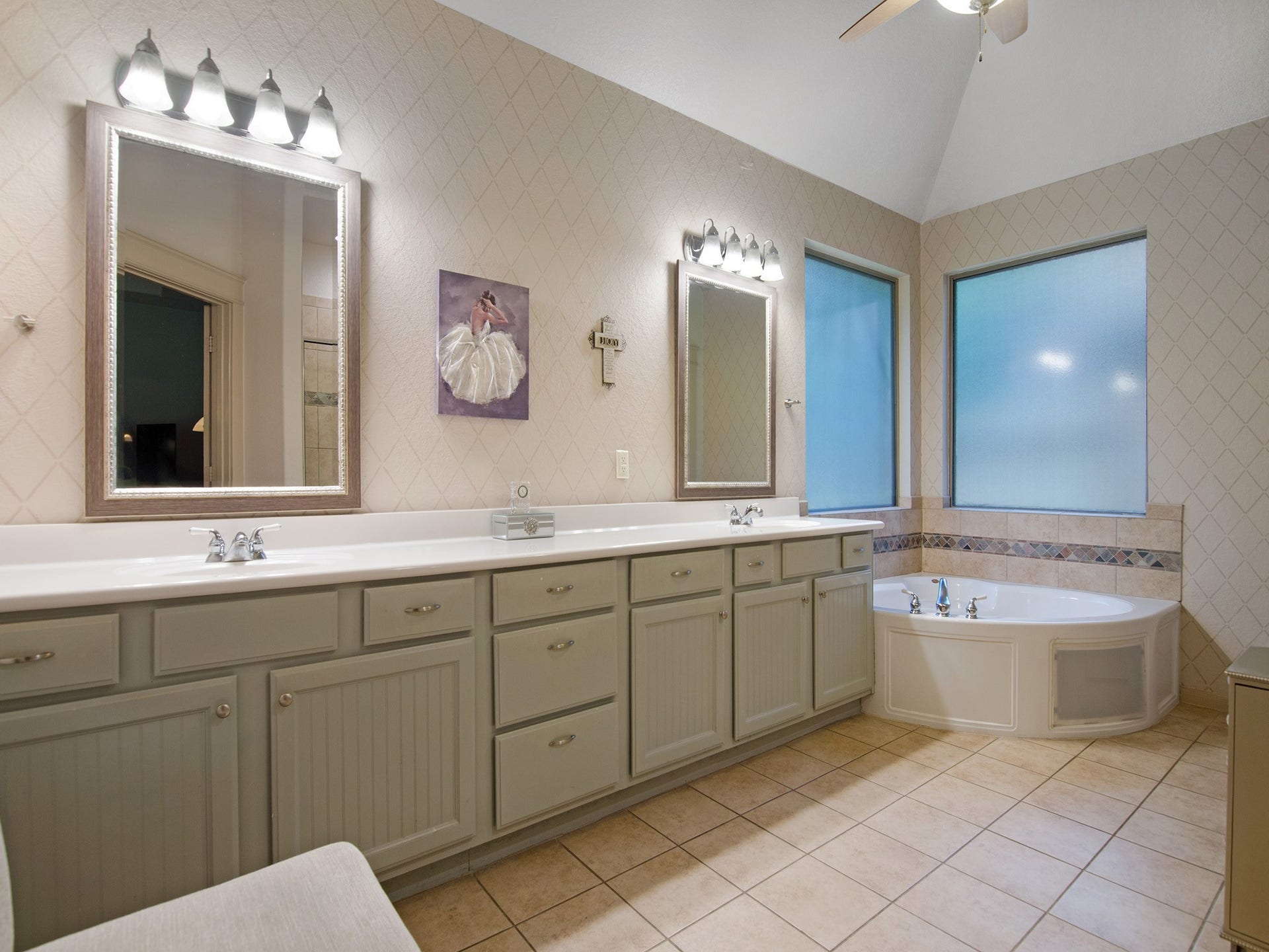 Bright and airy primary bath with relaxing garden tub and two oversized privacy windows and vaulted ceiling.
