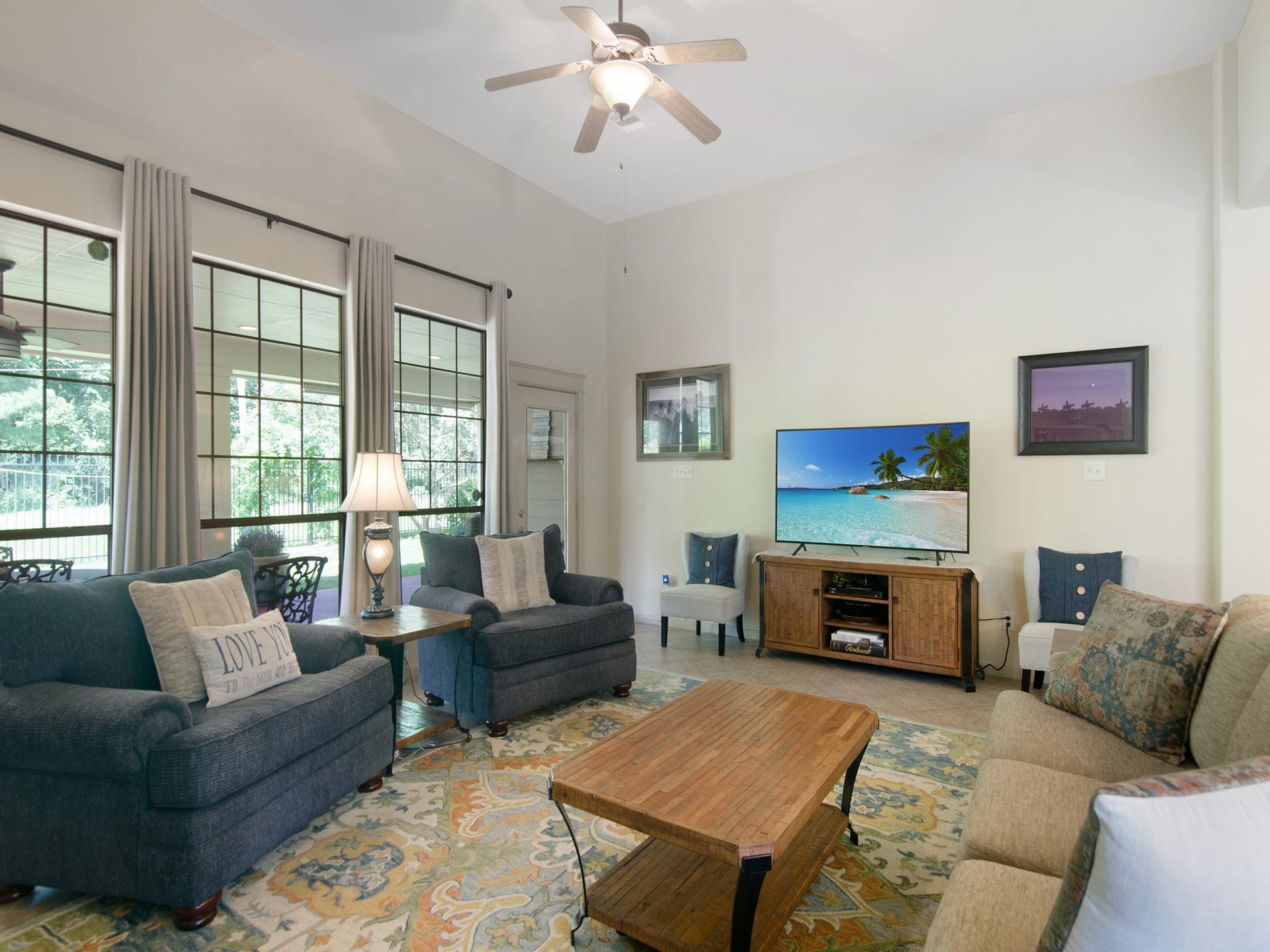Wall of windows frames peaceful backyard views and covered patio access.