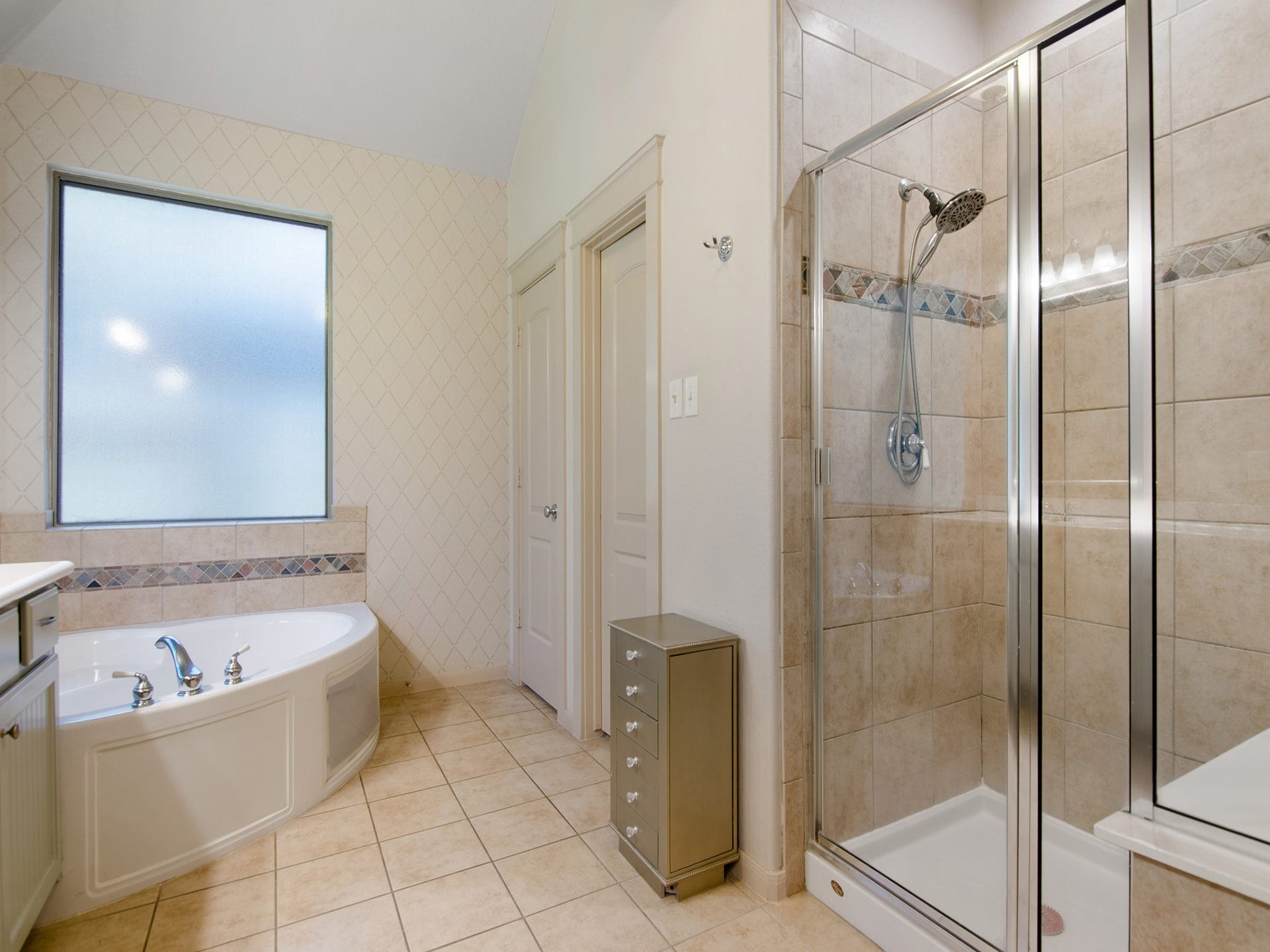 Primary bath features a walk-in shower, private commode room and large walk-in closet.