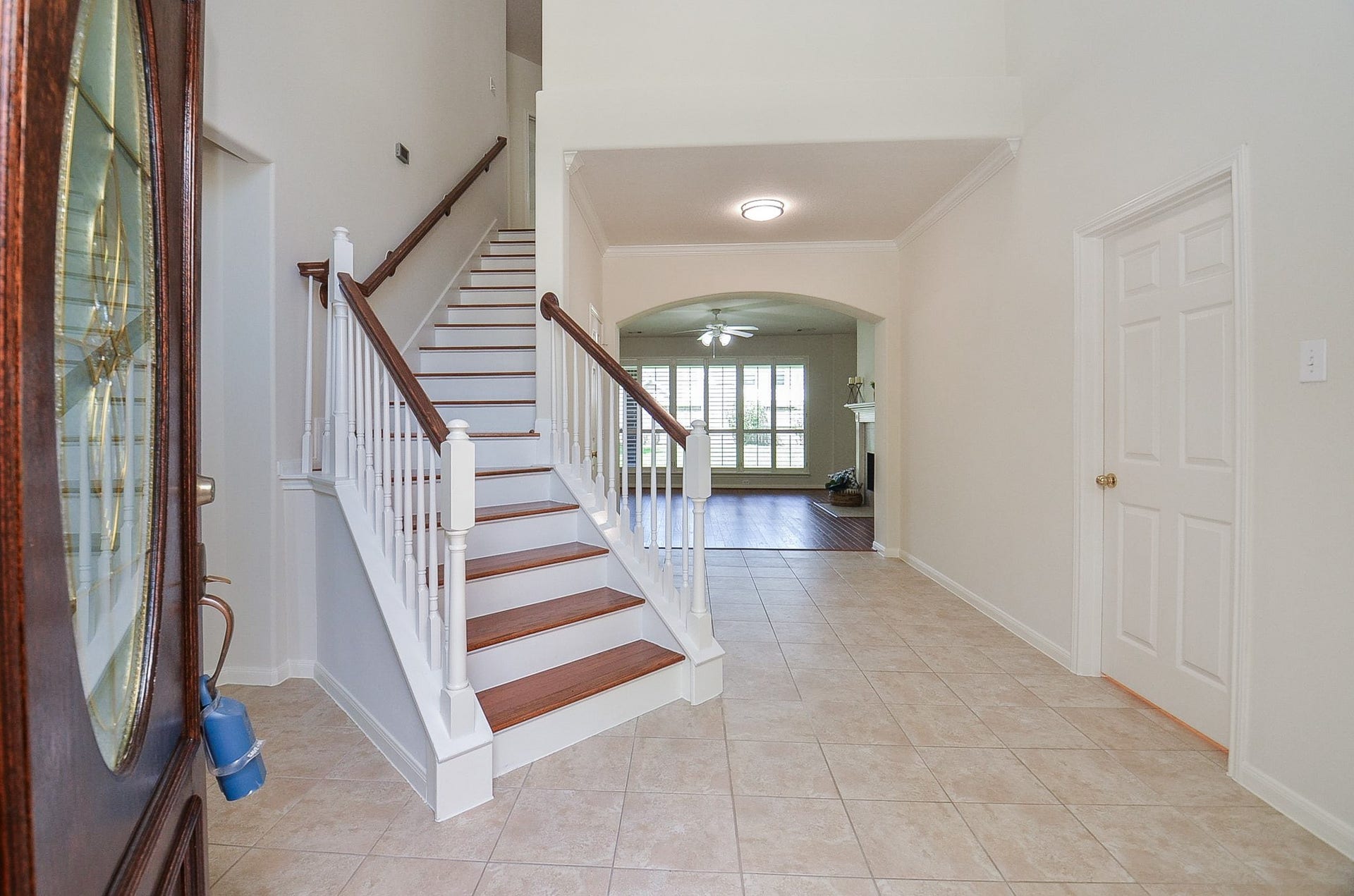 4746 Autumn Orchard Lane, Katy, TX 77494 Experience elegance with a high ceiling entryway leading to a spacious living area, featuring warm wood floors and a cozy fireplace, perfect for entertaining.