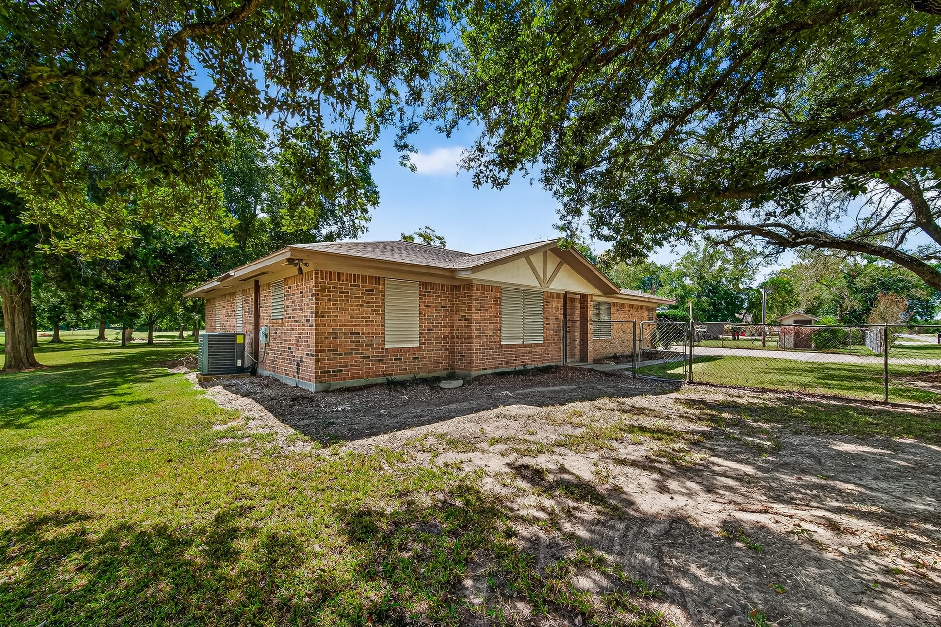 12021 7th 1/2 Street, Santa Fe, TX 77510 Charming brick home with a spacious, fenced yard and mature trees providing ample shade. Ideal for privacy and outdoor enjoyment.