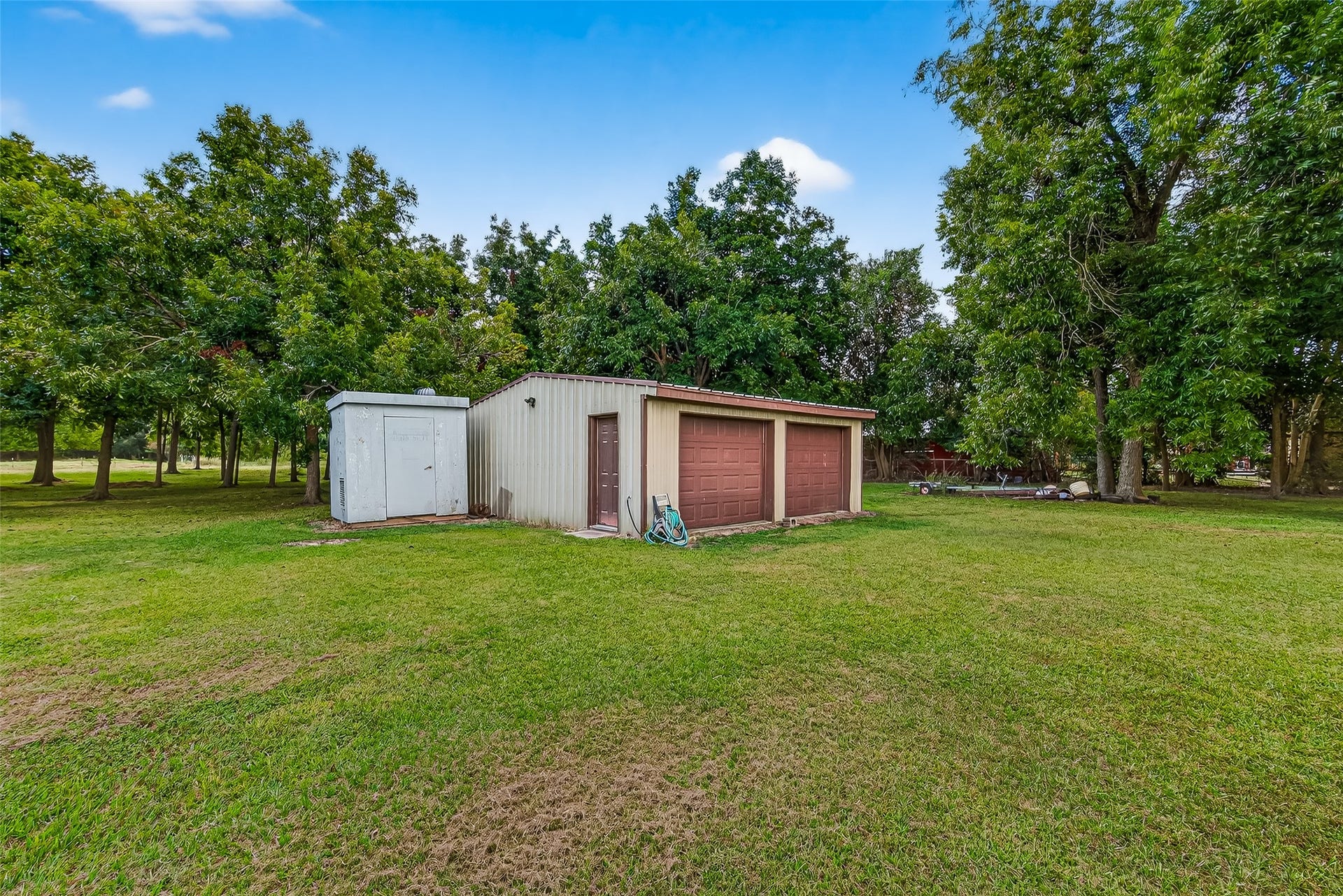 12021 7th 1/2 Street, Santa Fe, TX 77510 This photo shows a spacious backyard with a 24 x 24 workshop. The area is surrounded by offering a peaceful and private setting.